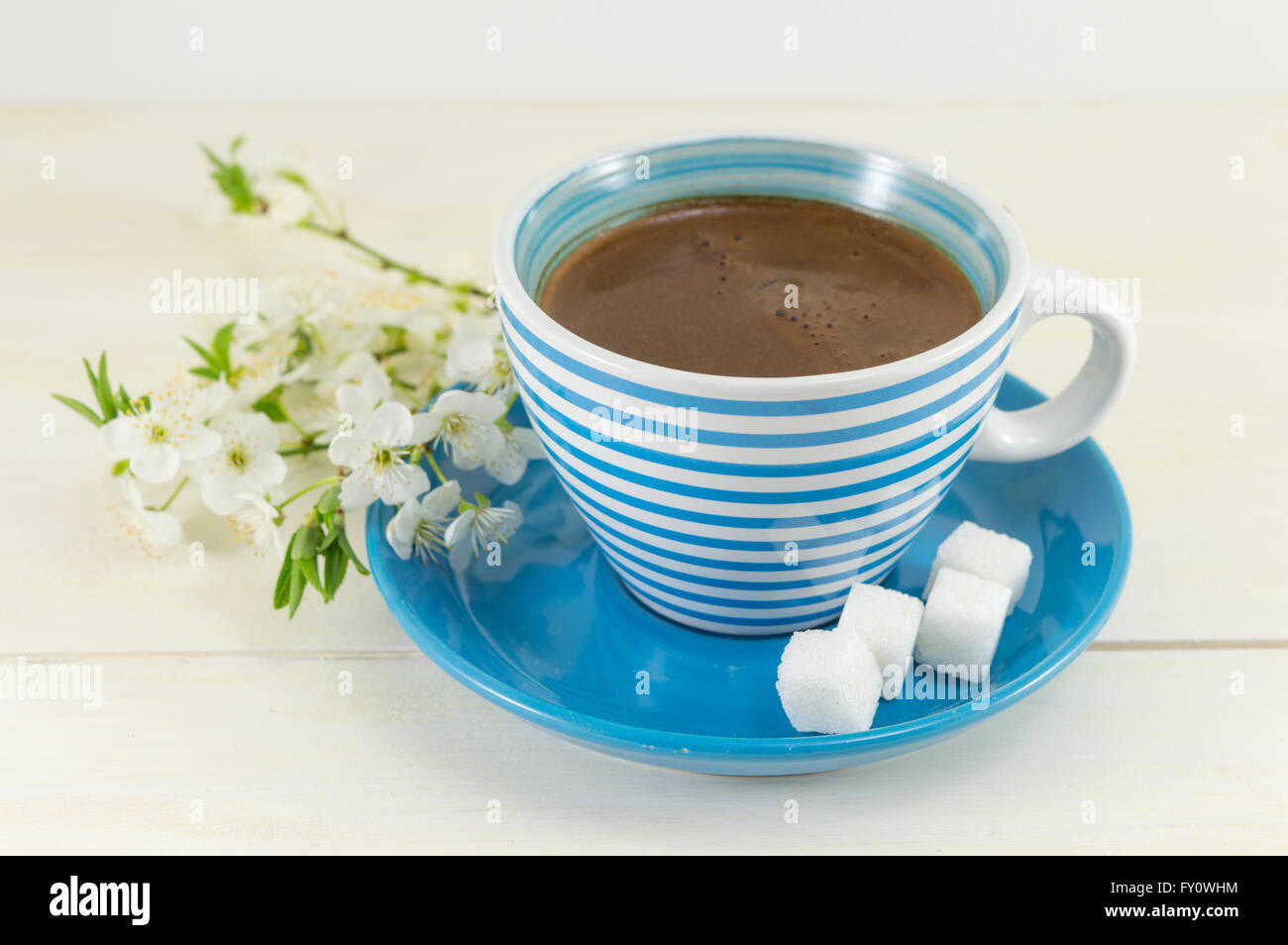 Kaffee mit Kirschblüten in einer blauen Tasse Stockfoto