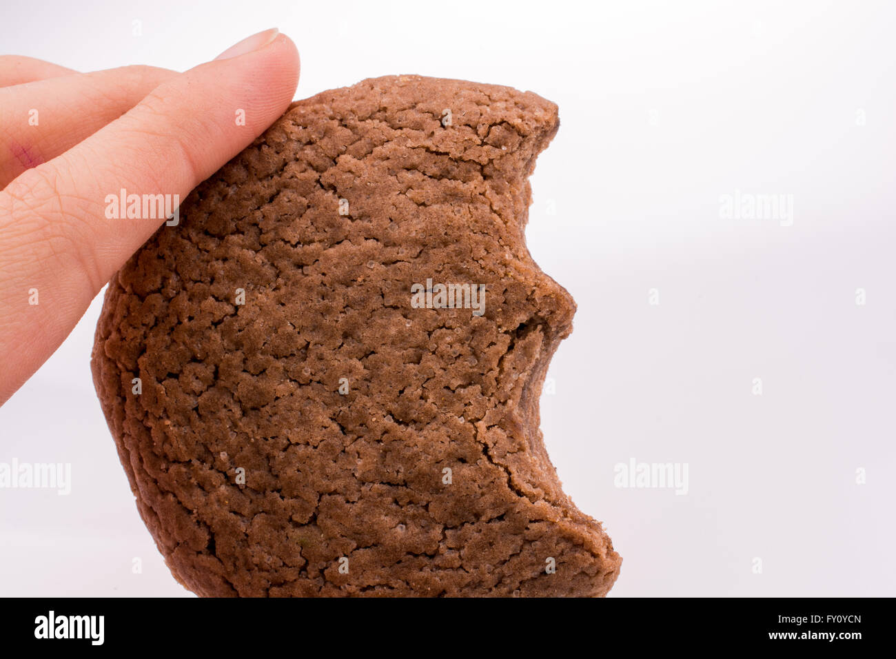 Hand, die gebissen Cookie auf weißem Hintergrund Stockfoto