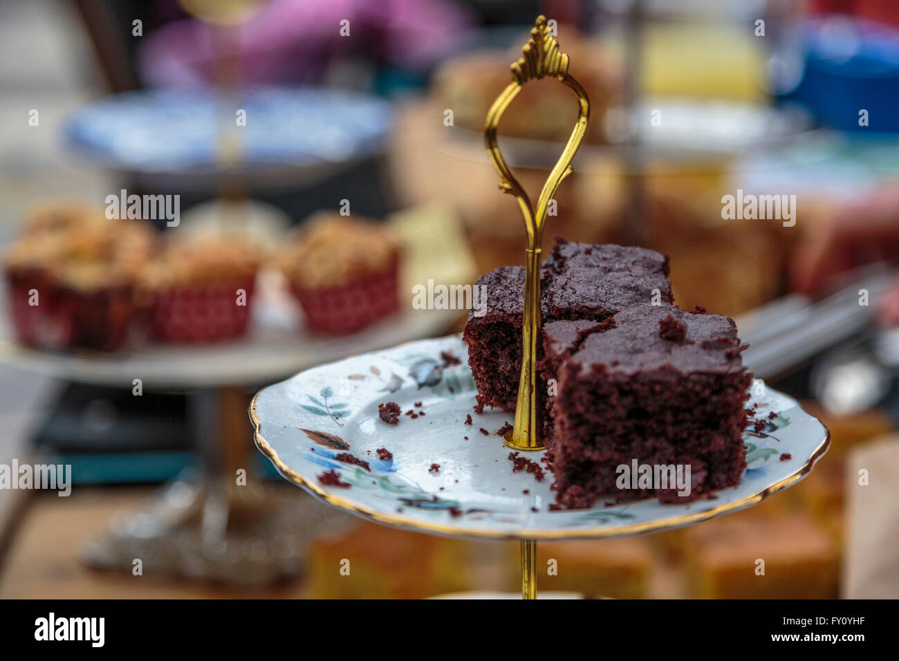 Ein hausgemachtes Stück Schokolade Brownie Kuchen auf einen reich verzierten China servieren Schüssel Wth gold Griff Stockfoto