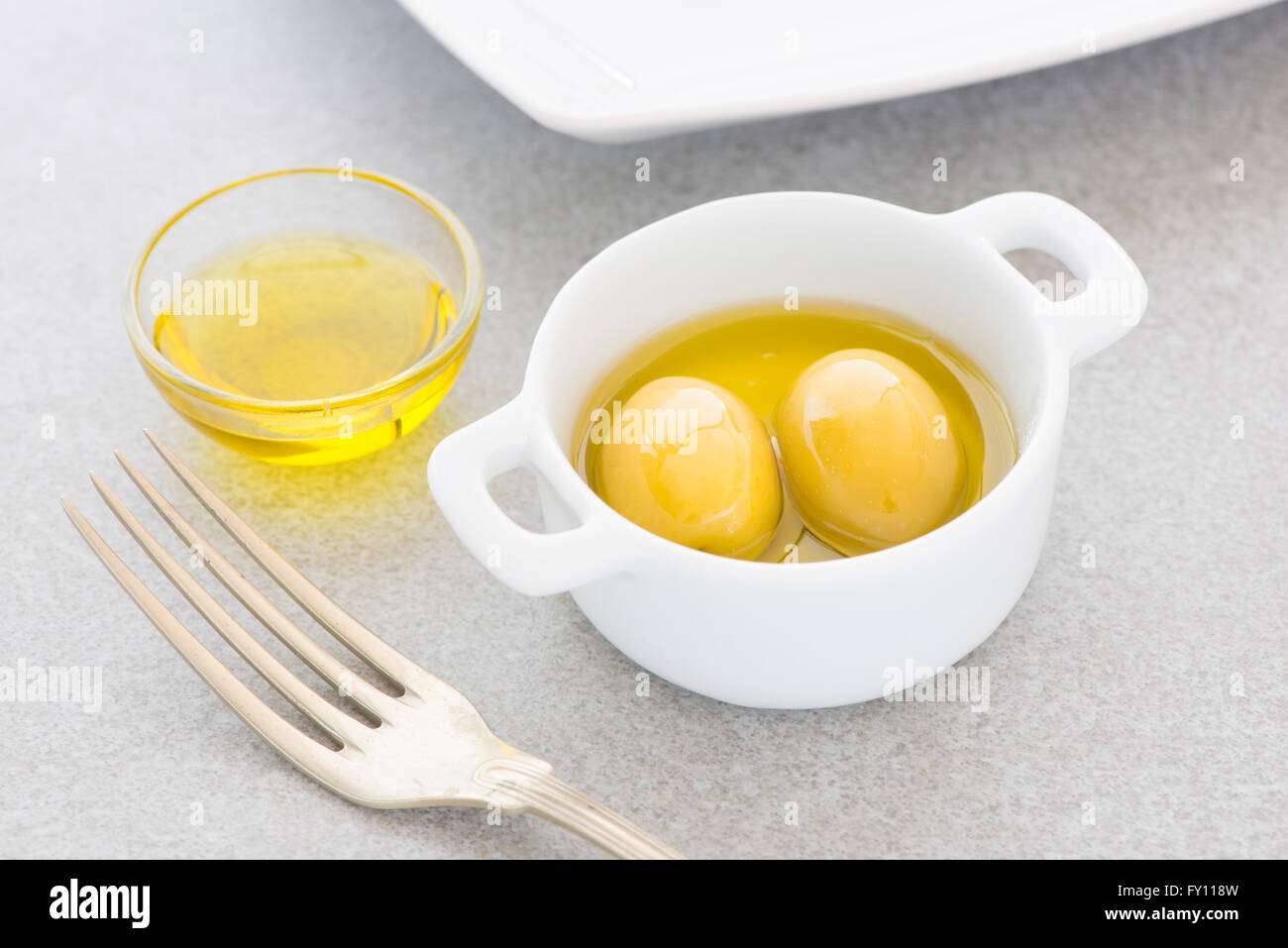Grüne Oliven und Olivenöl. Still-Leben Foto von Vorspeise oder Snack. Stockfoto