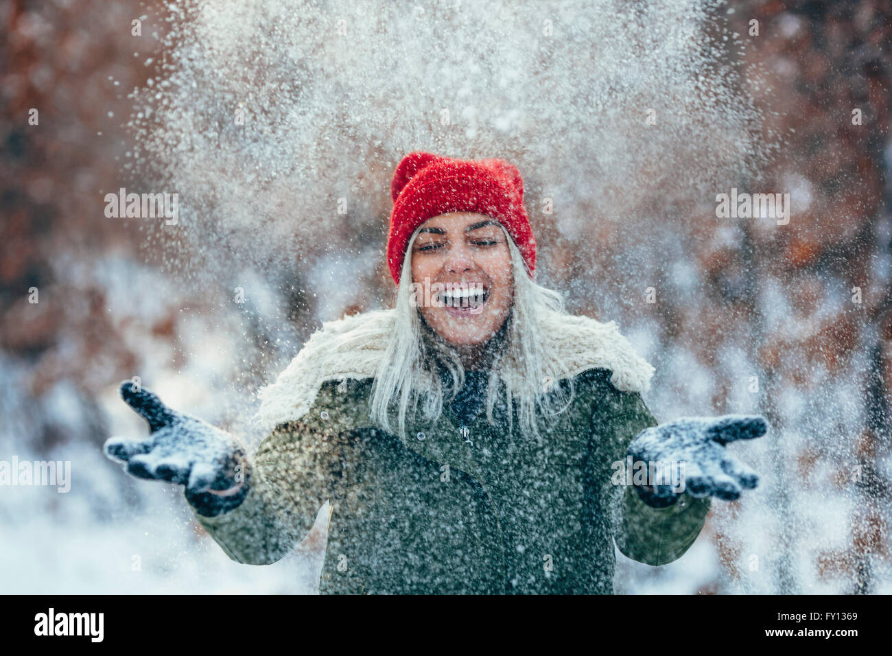 Glückliche junge Frau spielen im Schnee Stockfoto