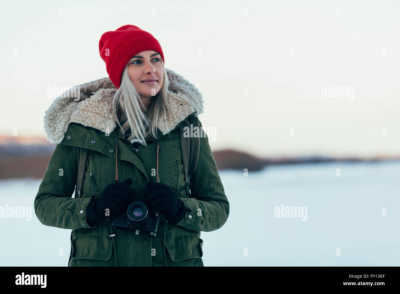 Nachdenkliche Frau mit Kamera genießen Wintersaison Stockfoto