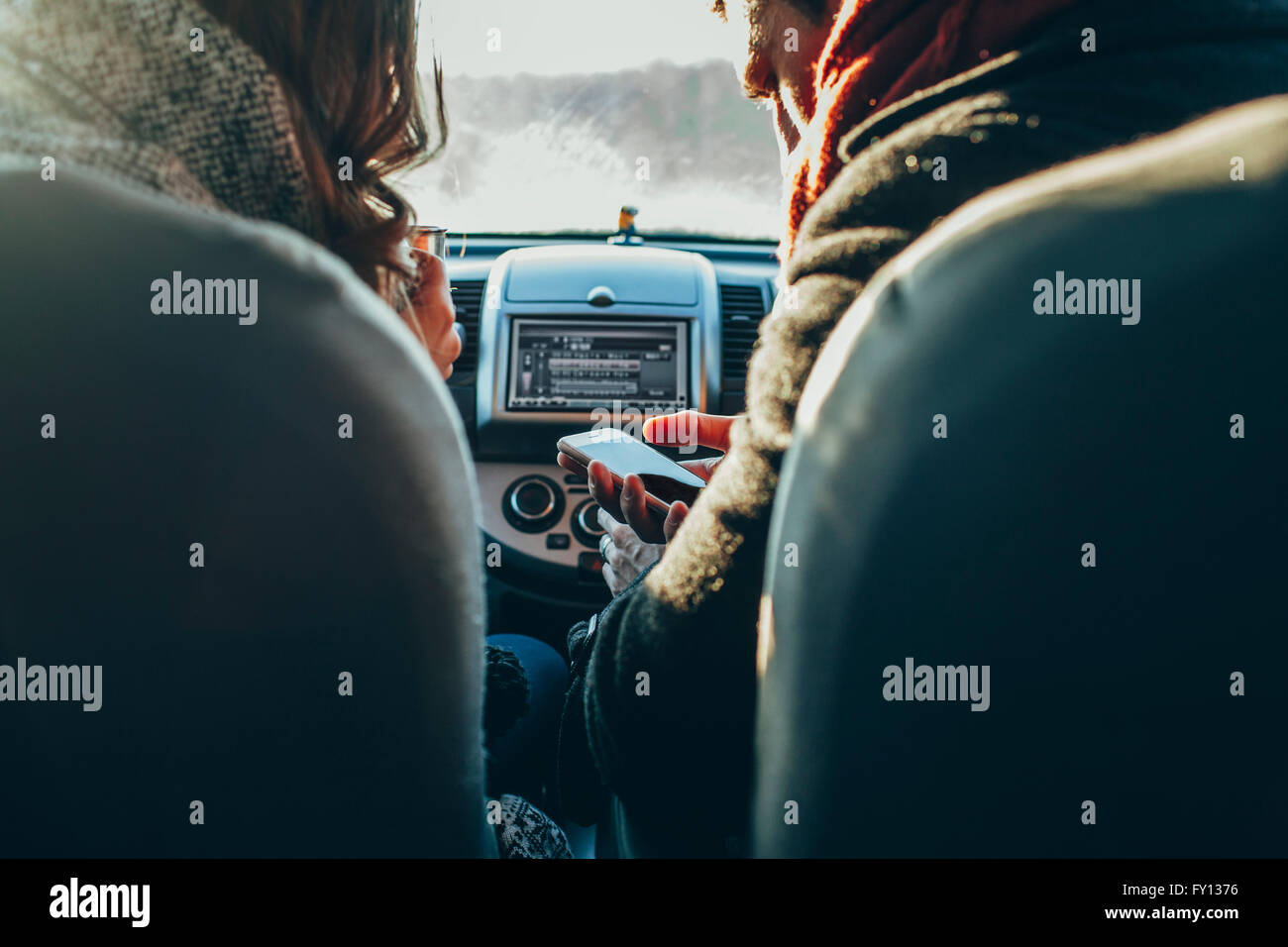 Bild des Paares mit Smartphone im Auto beschnitten Stockfoto