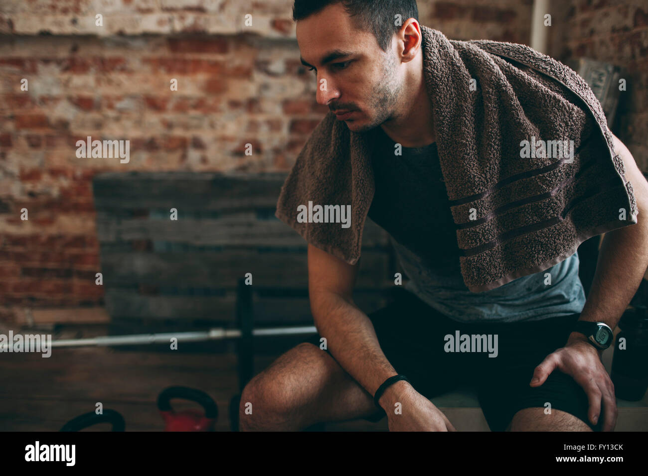 Nachdenklicher sportlichen Mann sitzen im Fitness-Studio Stockfoto