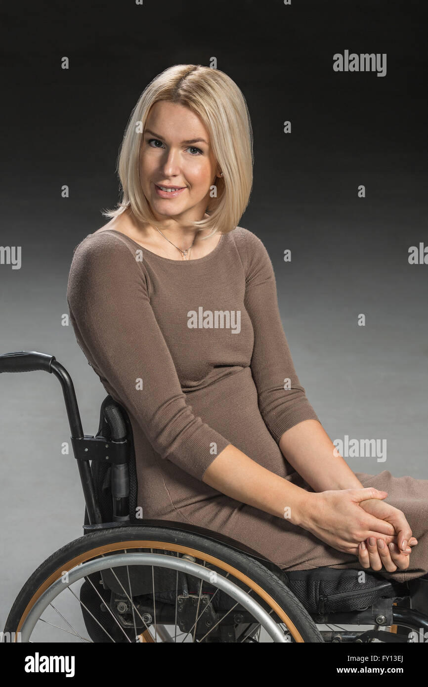 Porträt der selbstbewusste Frau, die im Rollstuhl sitzen Stockfoto