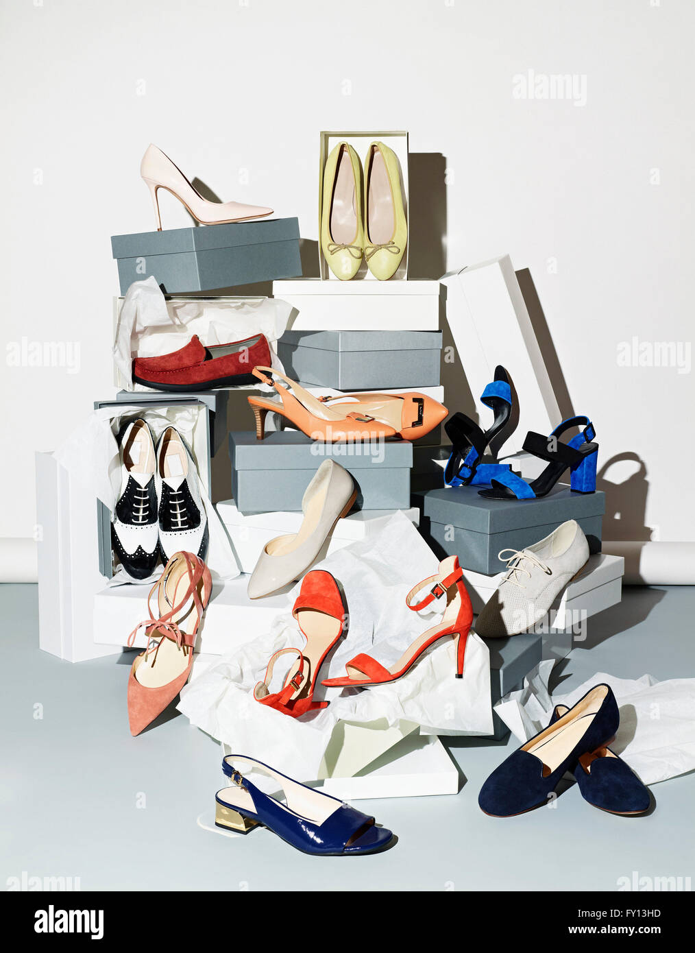 Verschiedene Paar Schuhe mit Boxen vor weißem Hintergrund Stockfoto