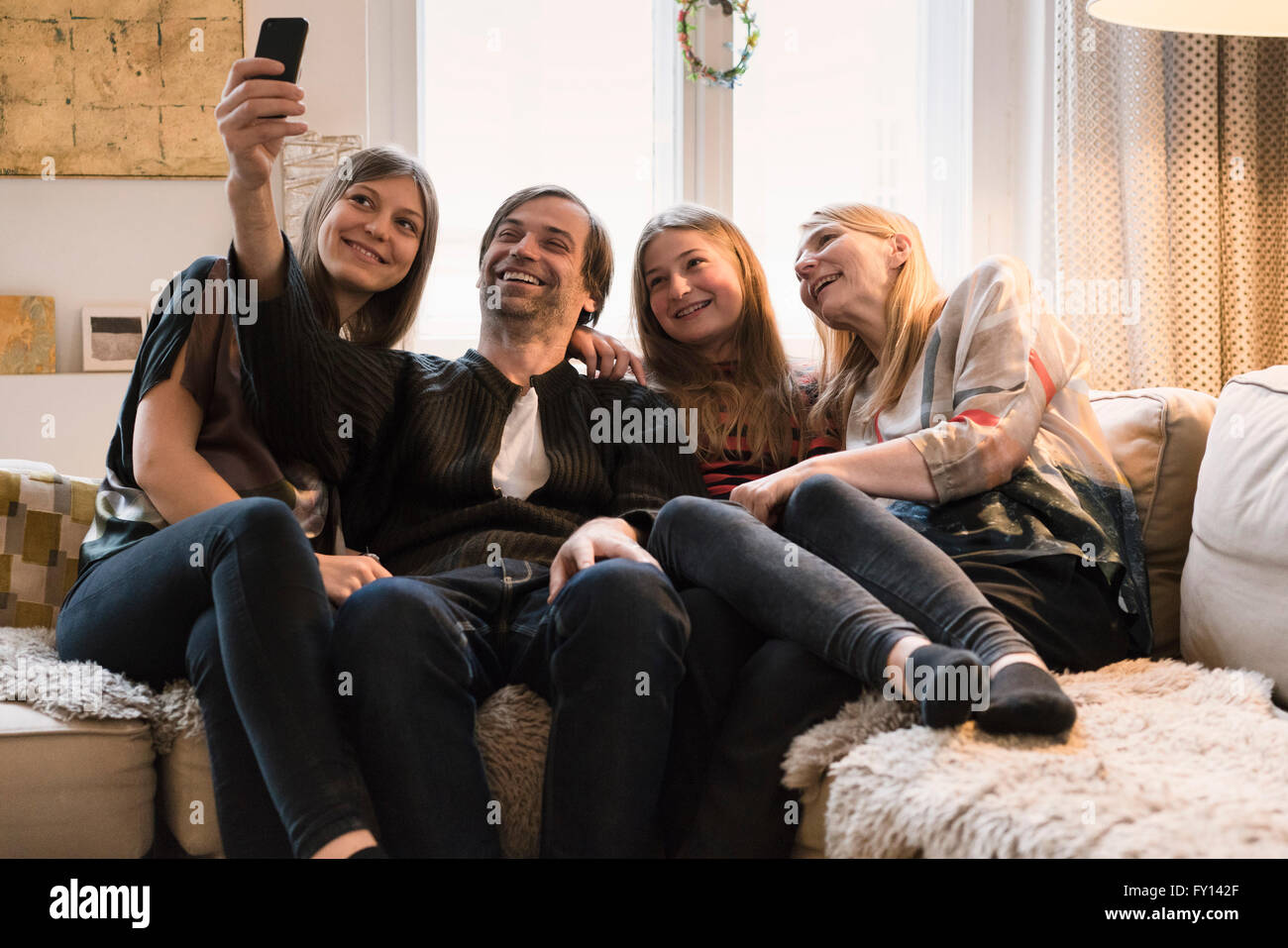 Glückliche Familie von vier reden Selfie über Mobiltelefon zu Hause Stockfoto