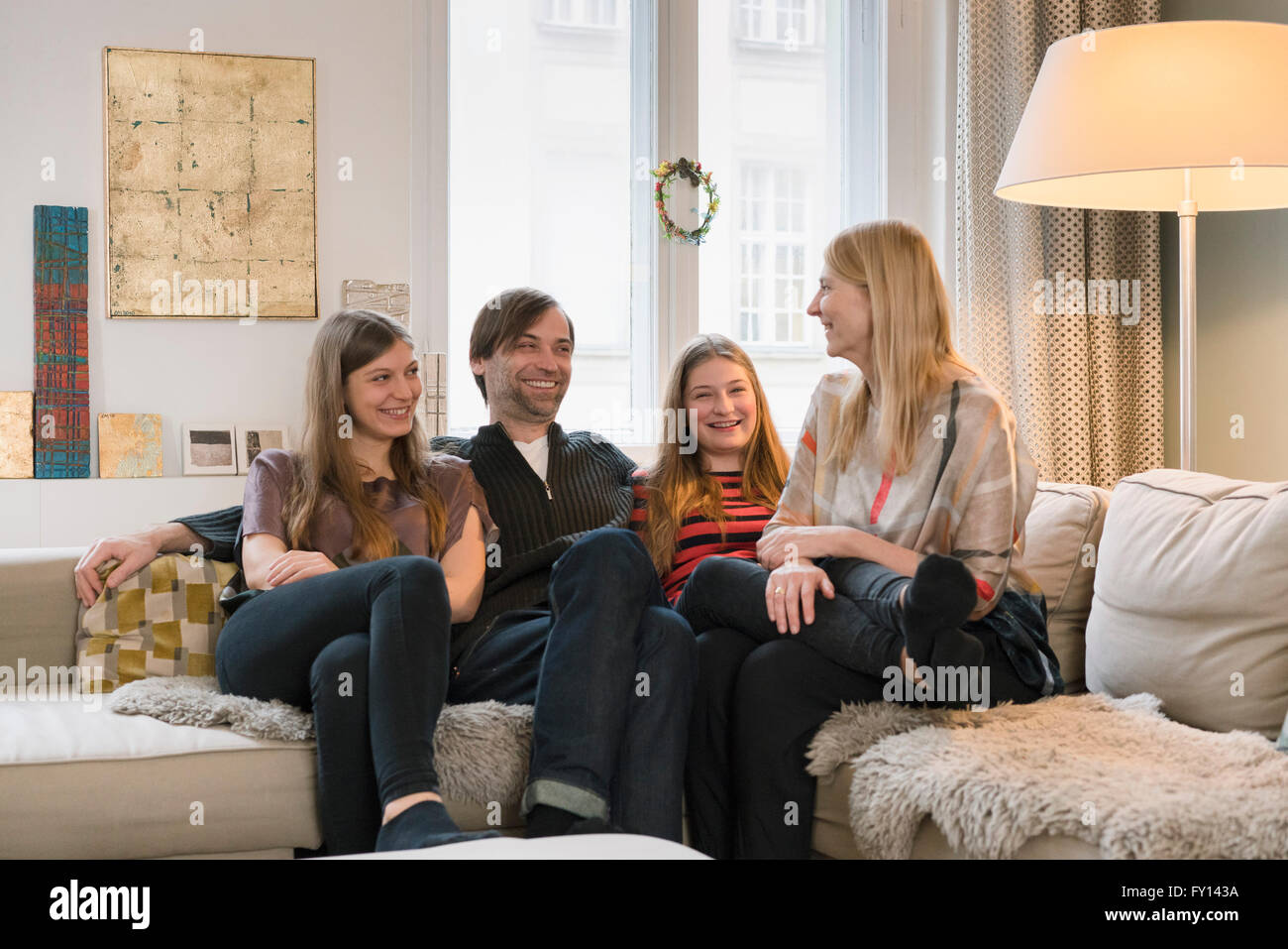 Glückliche Familie von vier sitzen zusammen auf dem Sofa zu Hause Stockfoto