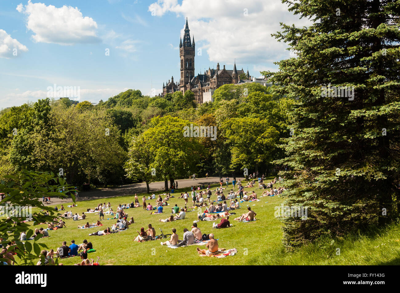Blick auf Kelvingrove Park voll von Menschen genießen den schottischen Sommer mit Hauptgebäude der Universität Glasgow auf Hügel Stockfoto