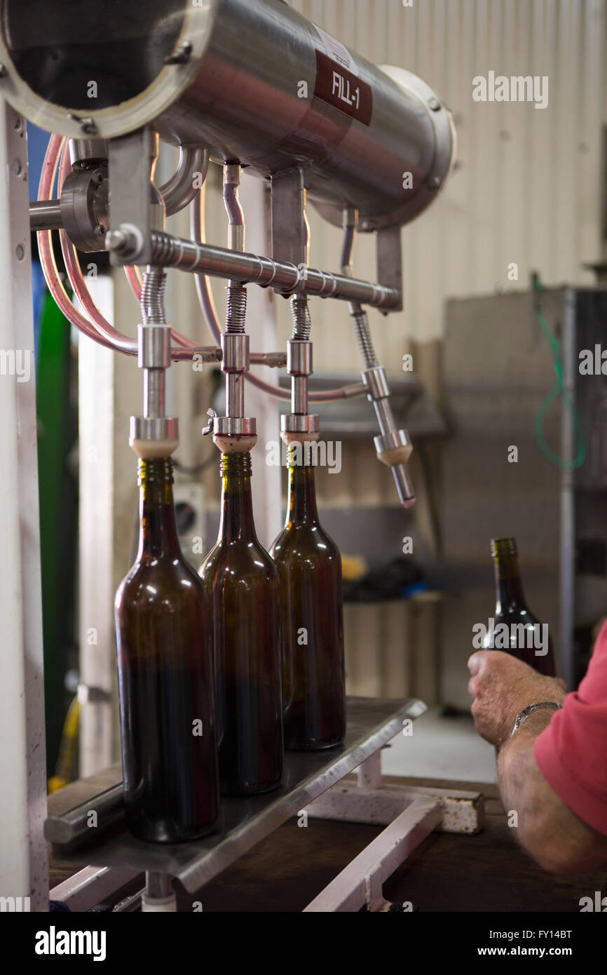 Bild eines Mannes mit Flasche in einer Fabrik beschnitten Stockfoto