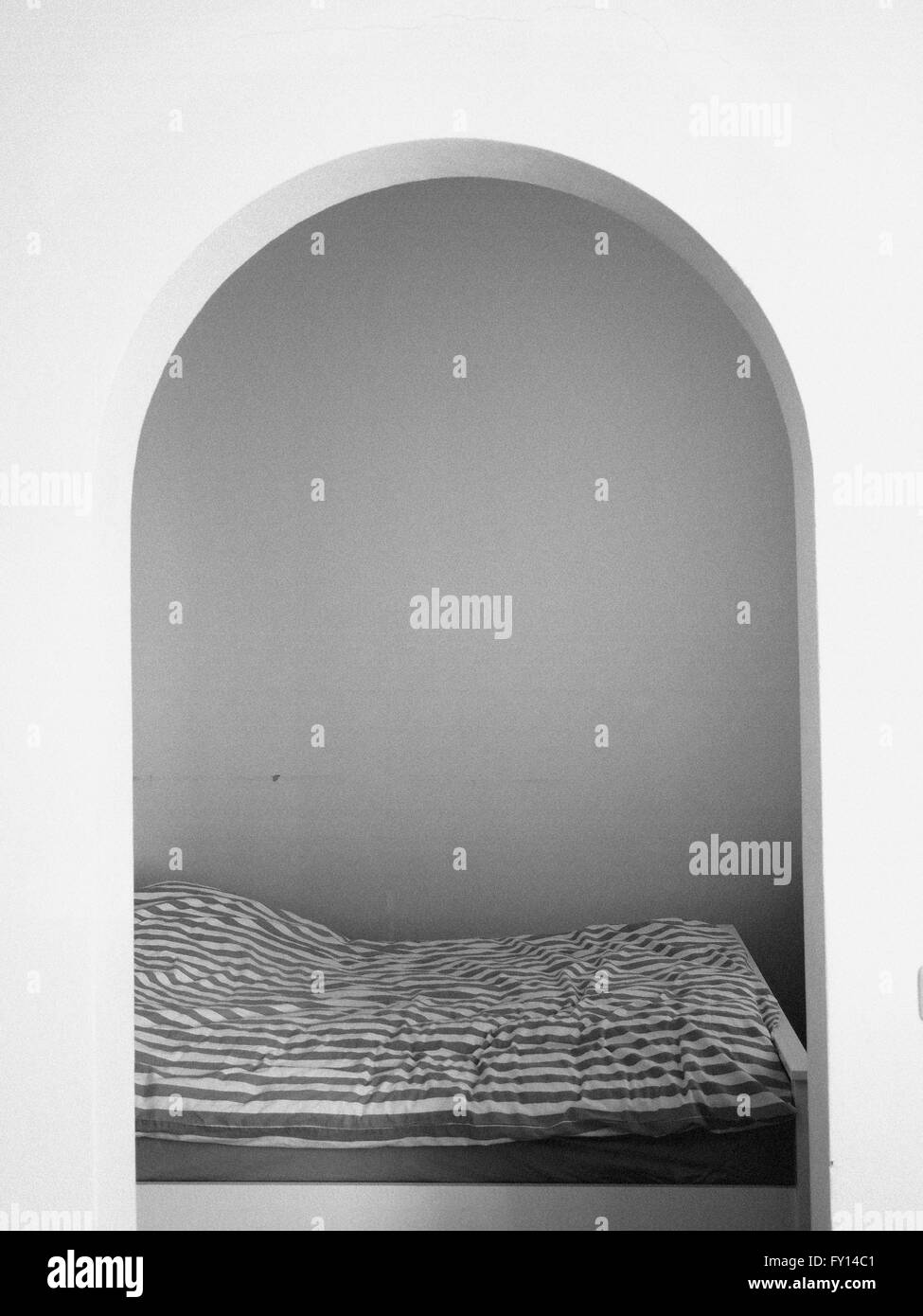 Bett und Zimmer gesehen durch einen Bogen Stockfoto