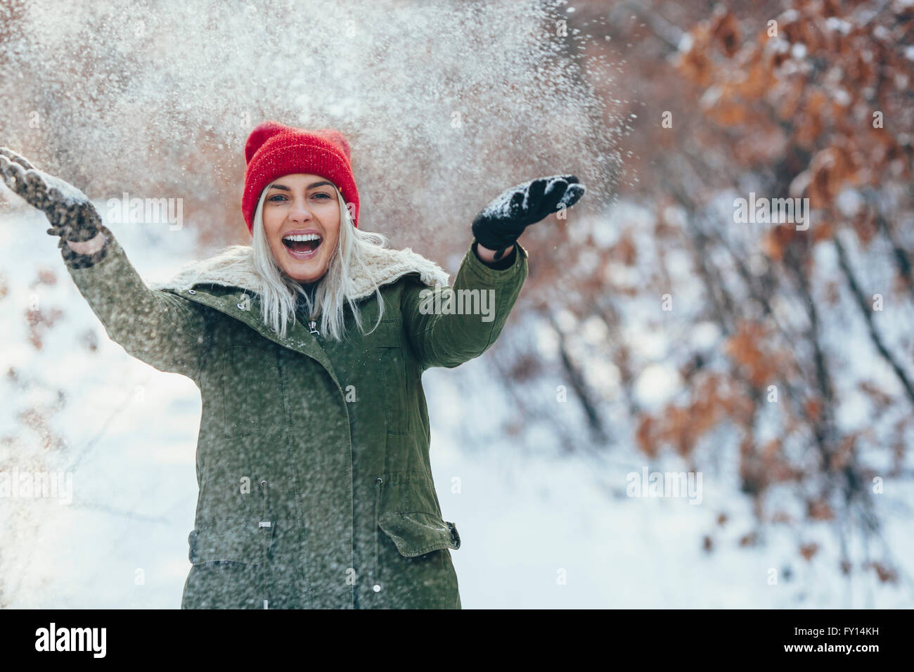 Porträt der glückliche junge Frau spielen im Schnee Stockfoto