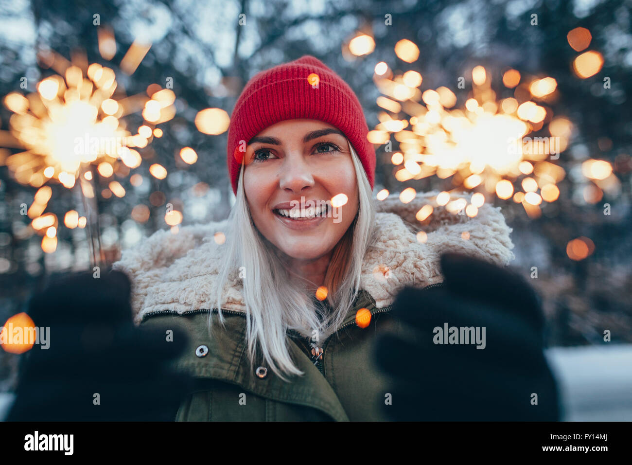 Glückliche Frau mit Wunderkerzen im winter Stockfoto