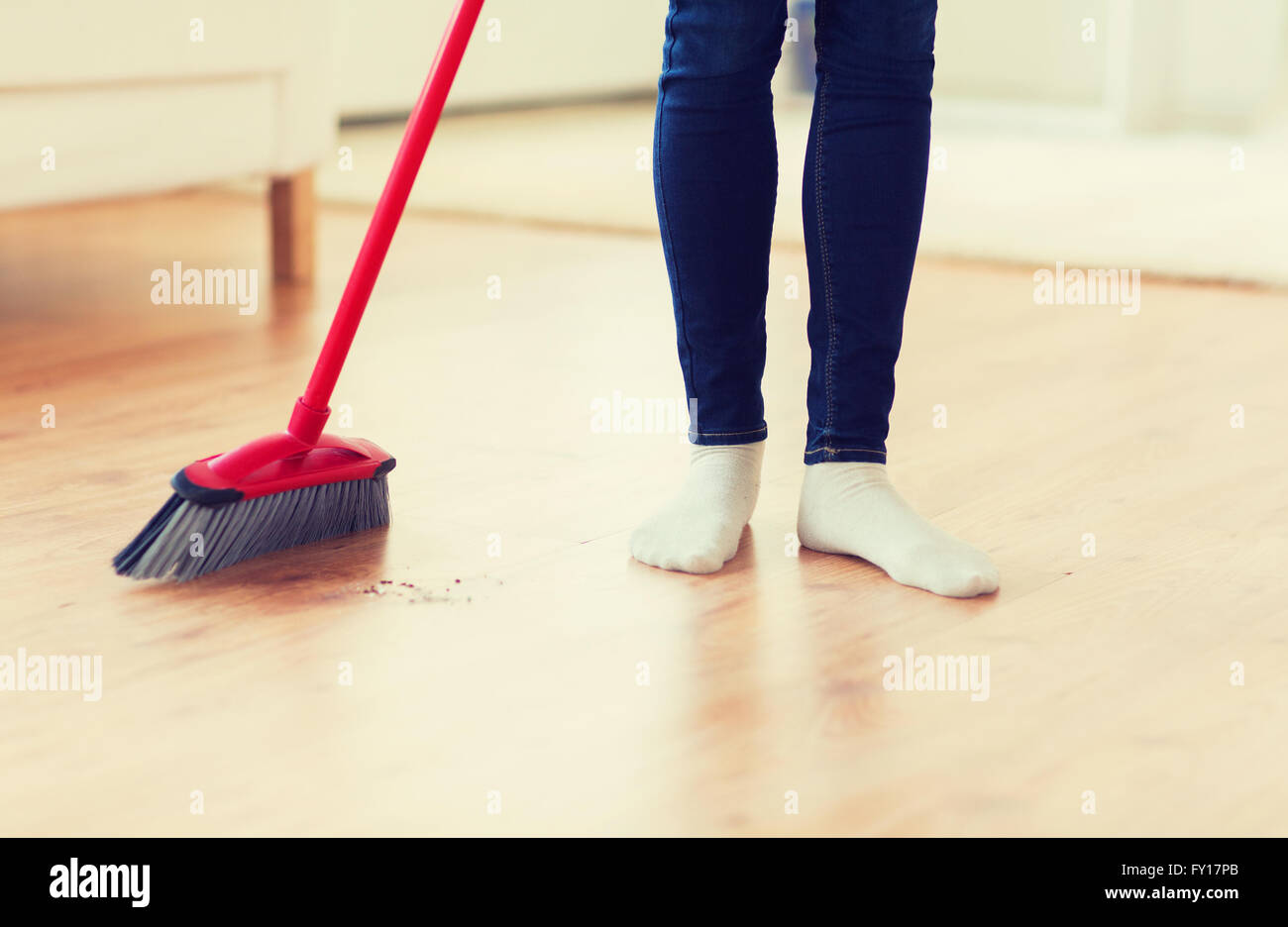 Nahaufnahme von Frau Beine mit Besen fegt Stock Stockfoto