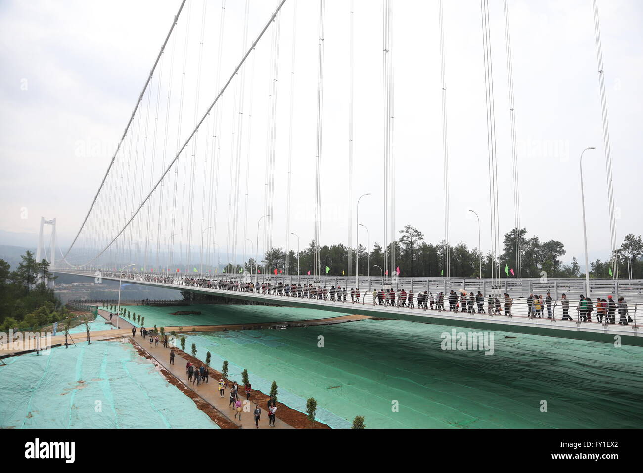 Kunming. 20. April 2016. Die Menschen gehen auf der neu eröffneten Longjiang grand Bridge in der südwestlichen chinesischen Provinz Yunnan, 20. April 2016. Die Longjiang grand Bridge auf Baoshan-Tengchong Autobahn mit einer Länge von über 2.470 Metern und einer Höhe von 280 Metern hat die längste Spanne unter allen Stahlkasten Träger Hängebrücken in bergigen Gebieten in Asien. Bildnachweis: Liu Zhengfan/Xinhua/Alamy Live-Nachrichten Stockfoto