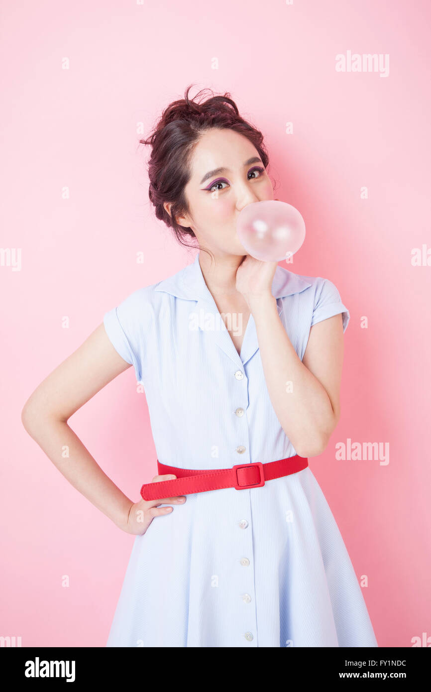 Junge lächelnde Frau im Retro-Stil, die Seifenblase Gum starrte auf Vorderseite Stockfoto