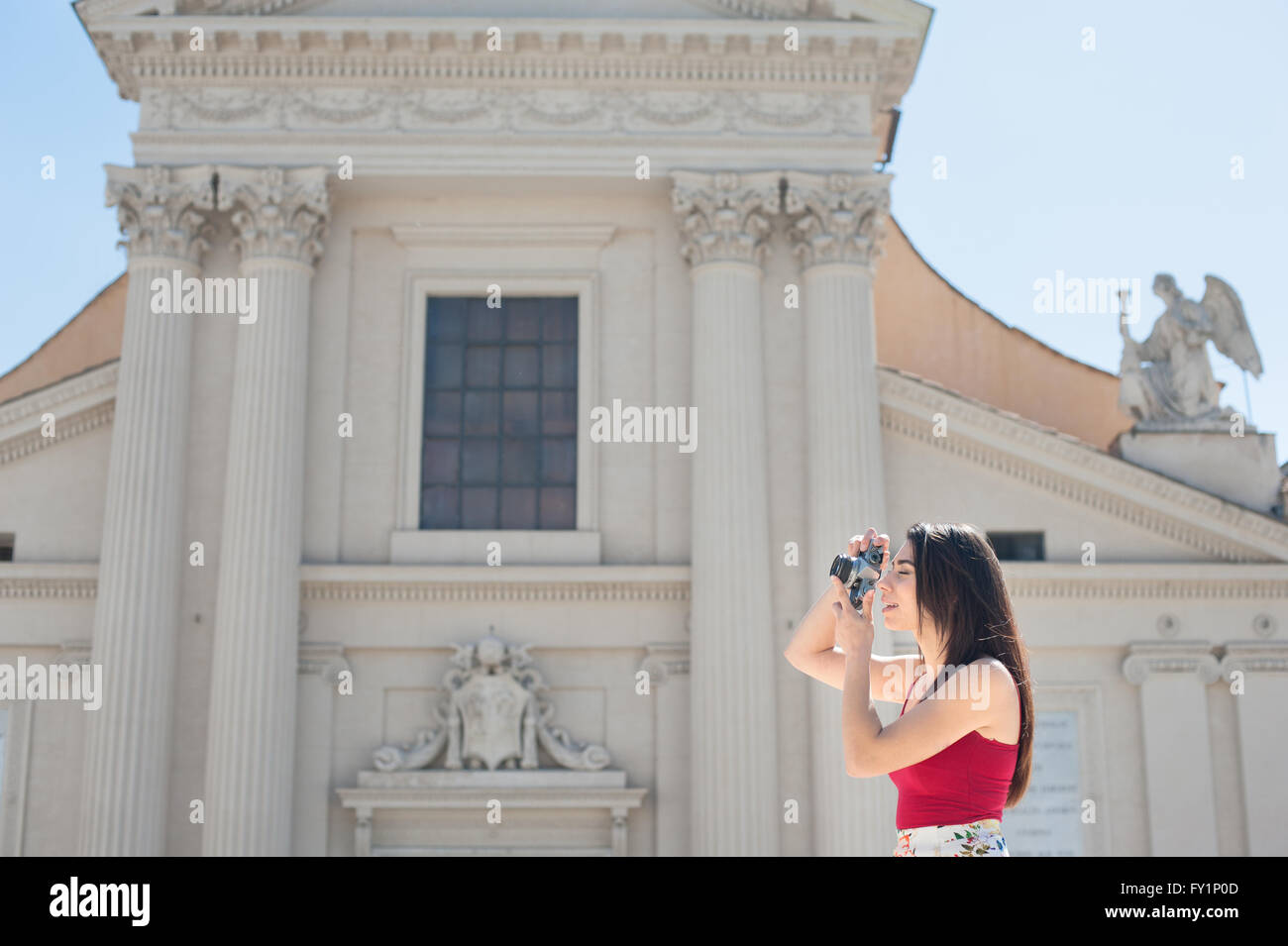 Junge Touristen Frau unter Bild mit Vintage-Kamera im Freien in Rom, Kirche im Hintergrund Stockfoto