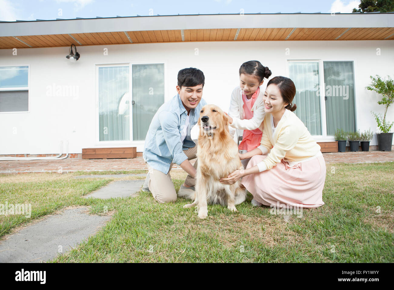 Familie Spaß mit ihrem Hund an den Hof ihres Hauses repräsentieren ländliche Leben Stockfoto