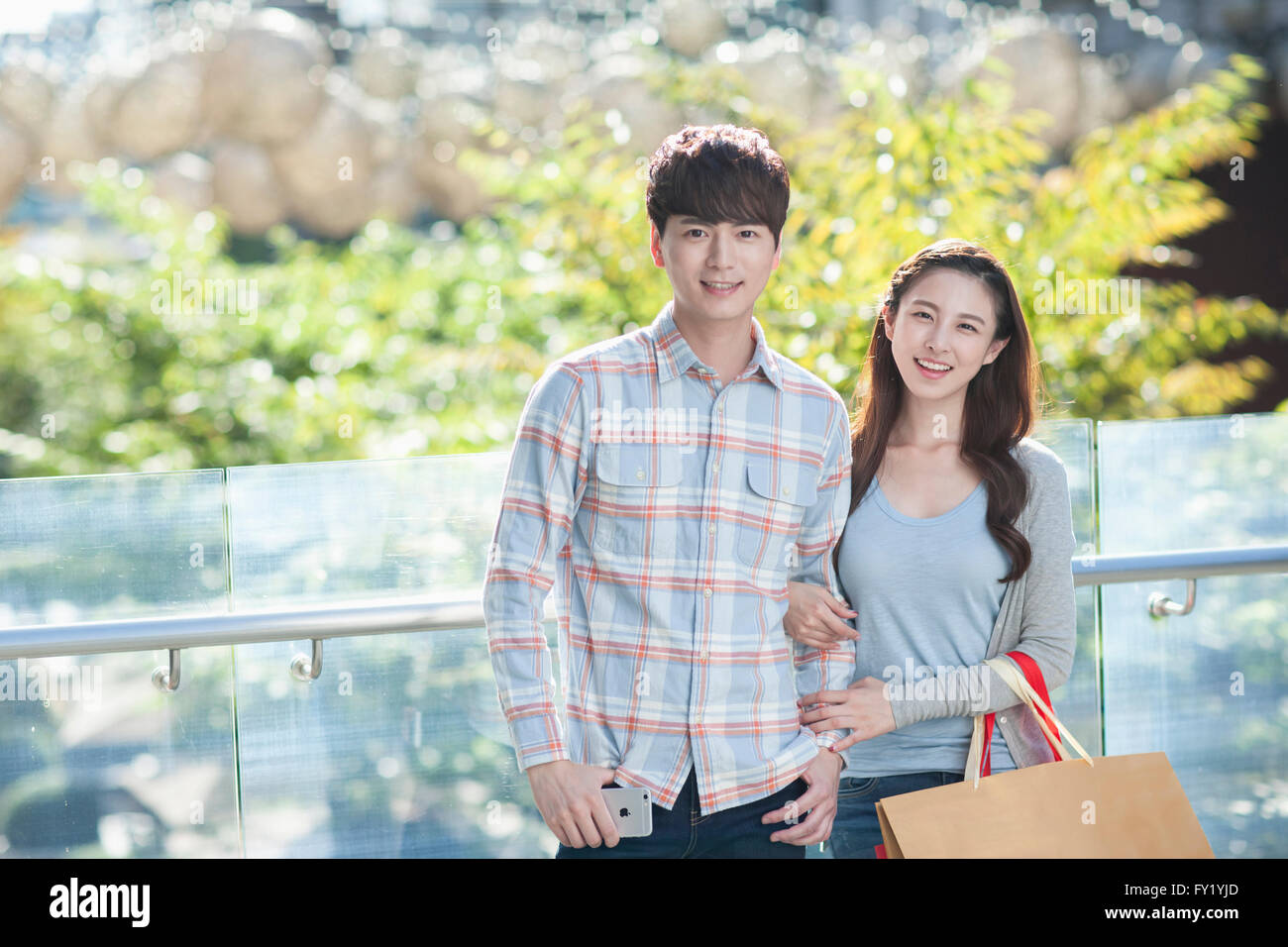 Paar in Liebe starrte mich mit einem Lächeln mit Einkaufstüten auf Frau arm Stockfoto