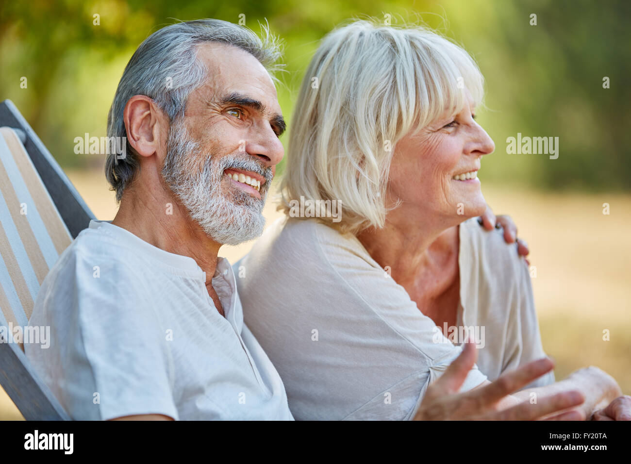 Gerne älteres Paar in Liebe sitzt entspannt im Sommer in der Natur Stockfoto
