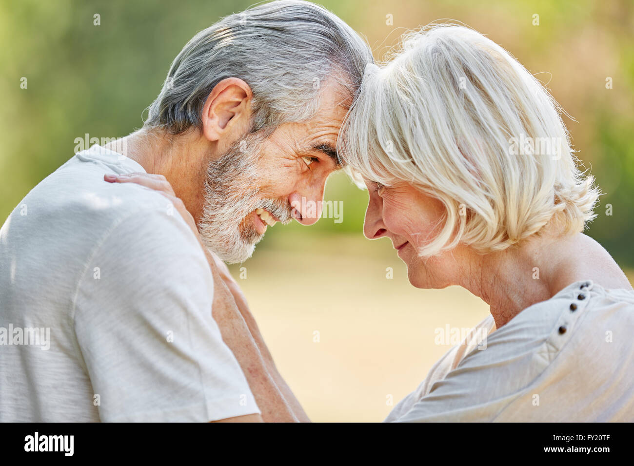 Senioren in Liebe flirten und schauen einander in die Augen in der Natur Stockfoto