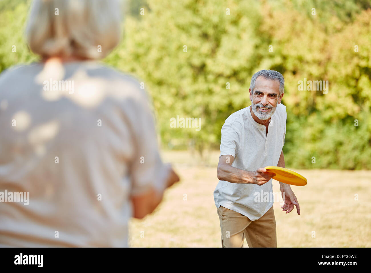 Aktive Senioren im Sommer in der Natur mit einer Frisbee spielen Stockfoto