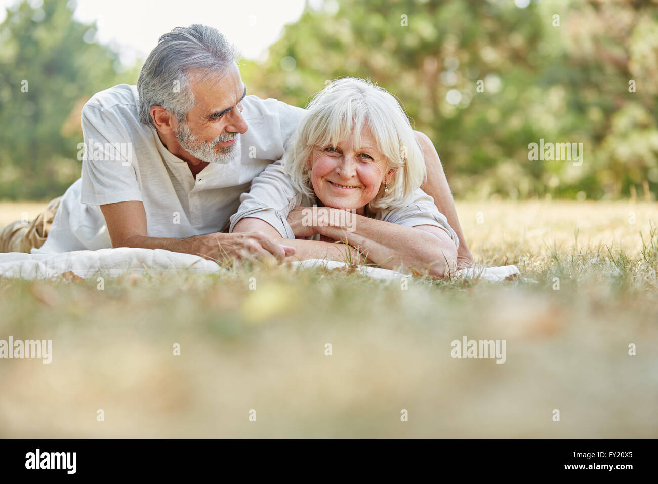 Gerne älteres Paar in Liebe entspannt auf die Gras im Sommer Stockfoto