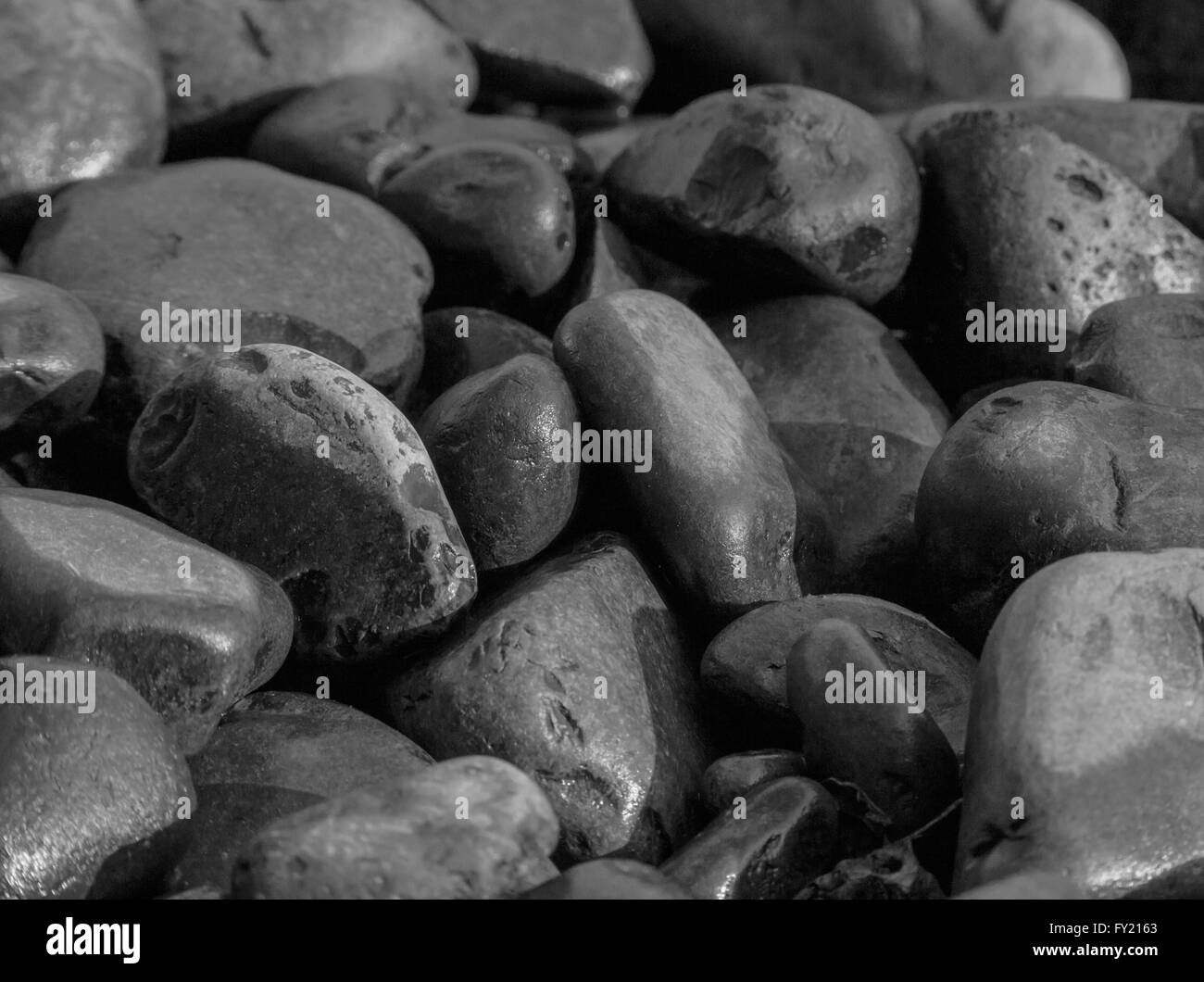 schwarz / weiß Foto des Haufens von nassen Steinen Stockfoto