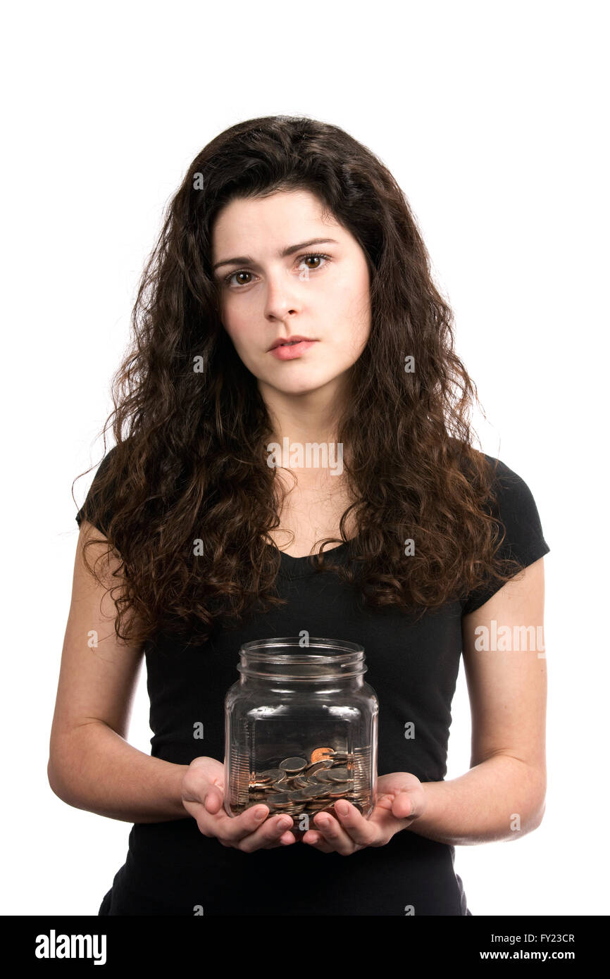 Junge Frau hält ein Glas Geld mit einem fragenden Blick auf ihrem Gesicht, eine unzureichende Ersparnisse Konzept darzustellen. Stockfoto