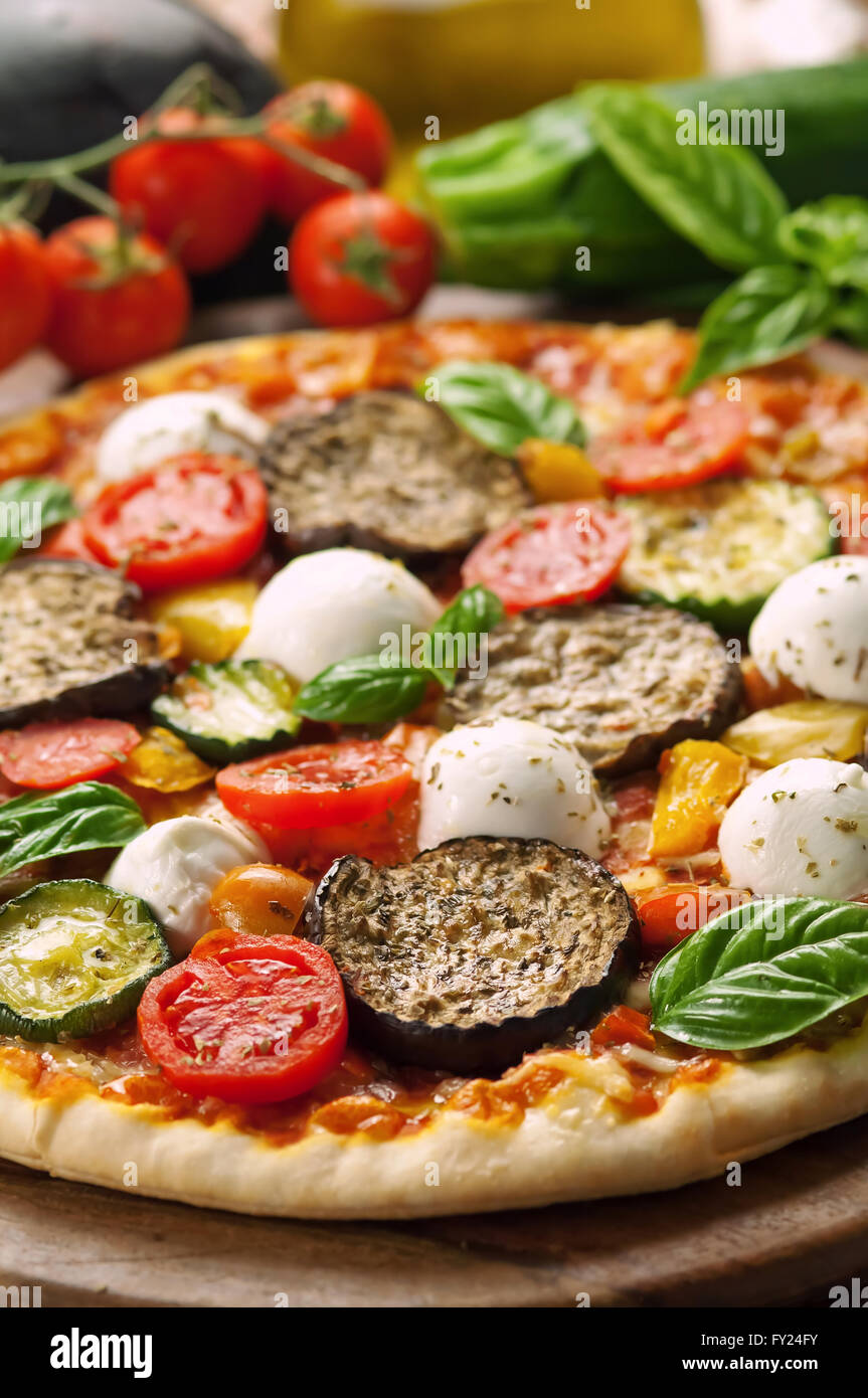 Vegetarische Pizza mit frischen Zutaten auf Holzplatte Stockfoto