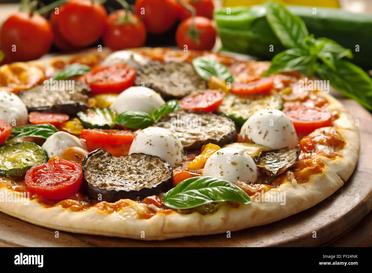 Vegetarische Pizza mit frischen Zutaten auf Holzplatte Stockfoto