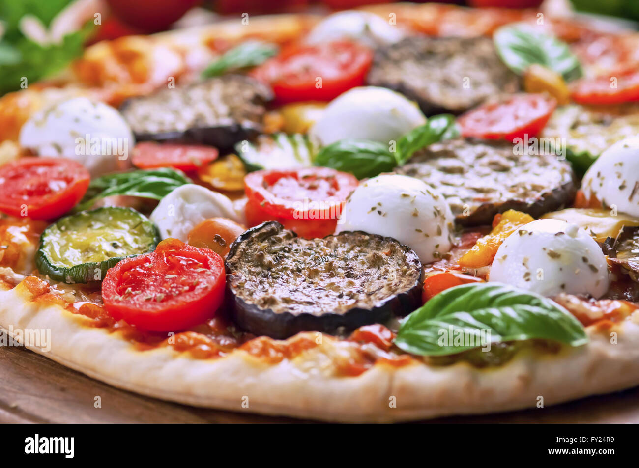 Vegetarische Pizza mit frischen Zutaten auf Holzplatte Stockfoto
