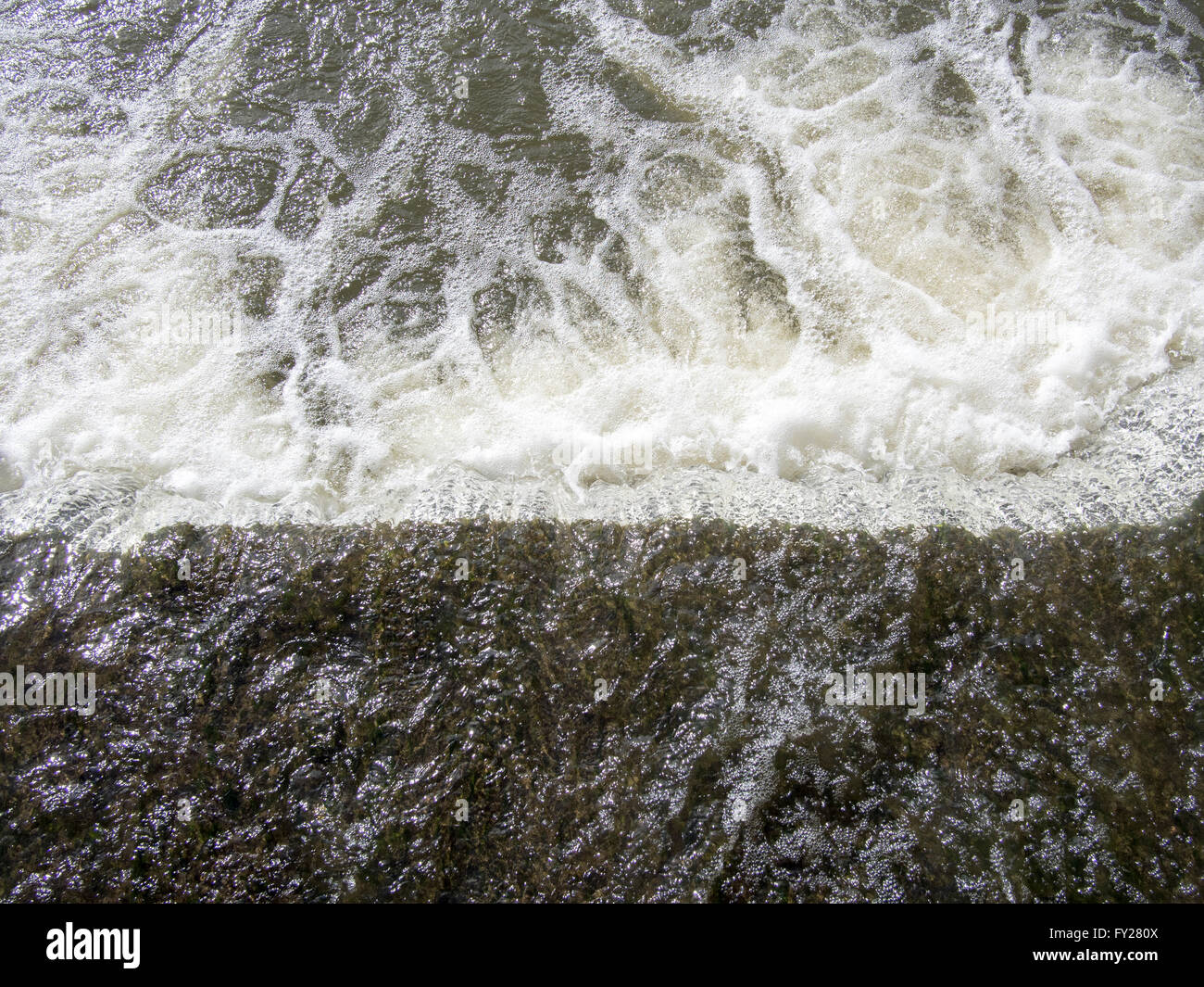 Flusswasser hetzen über ein Wehr. Stockfoto