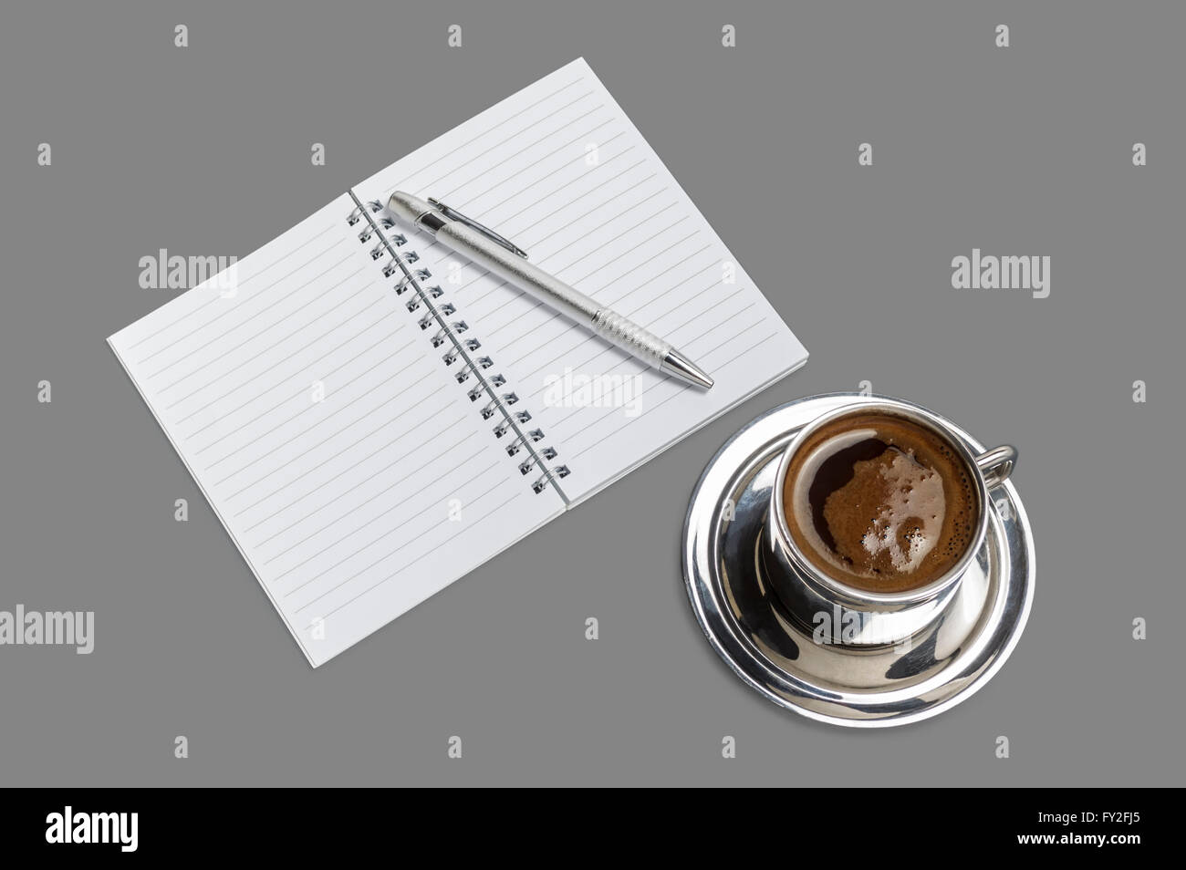 Kaffeebecher mit offenen leeren Notizbuch und Bleistift auf grauem Hintergrund isoliert. Stockfoto