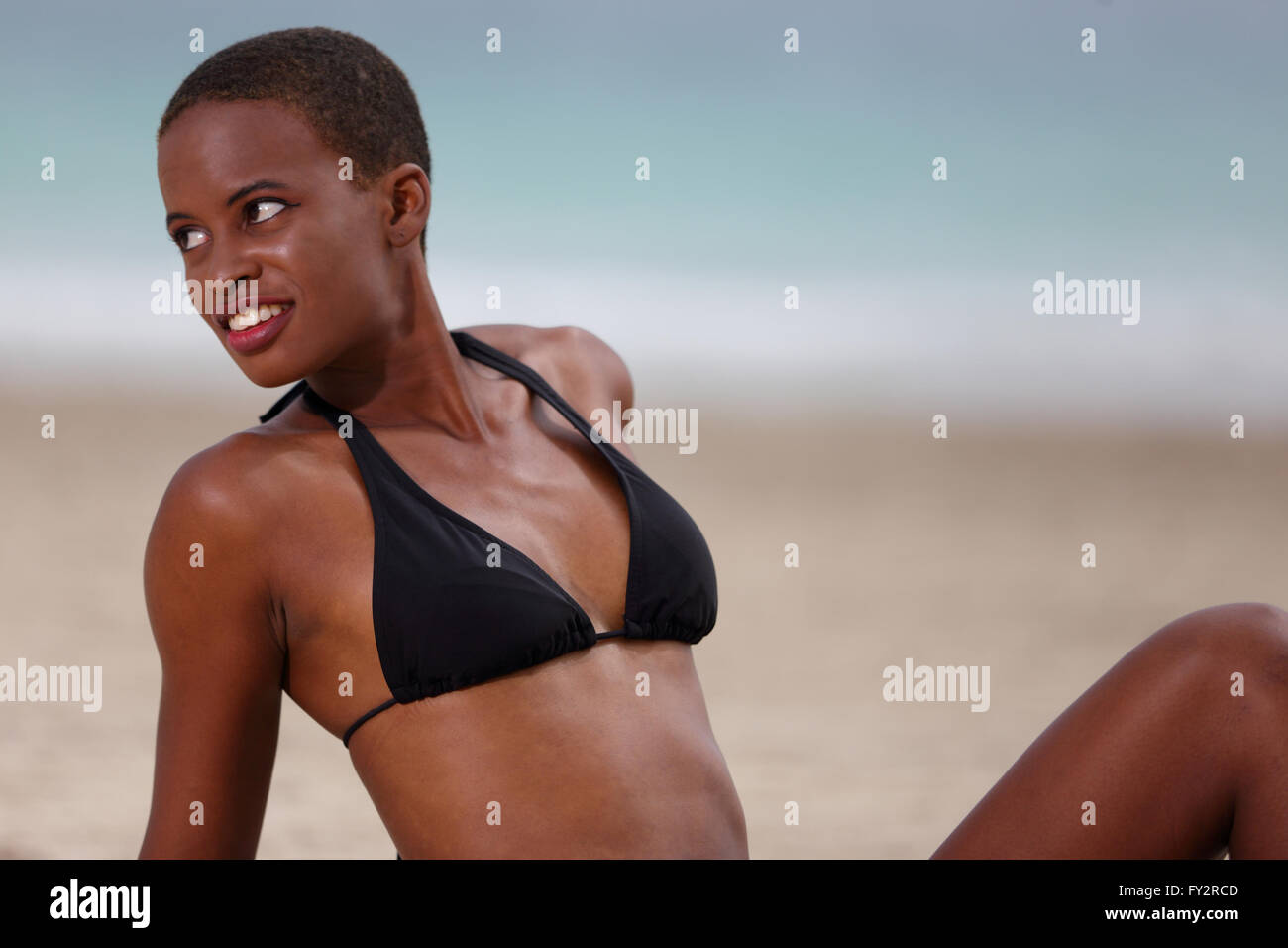 Frau in einem Bikini-Oberteil, Sonnenbaden am Strand Stockfoto