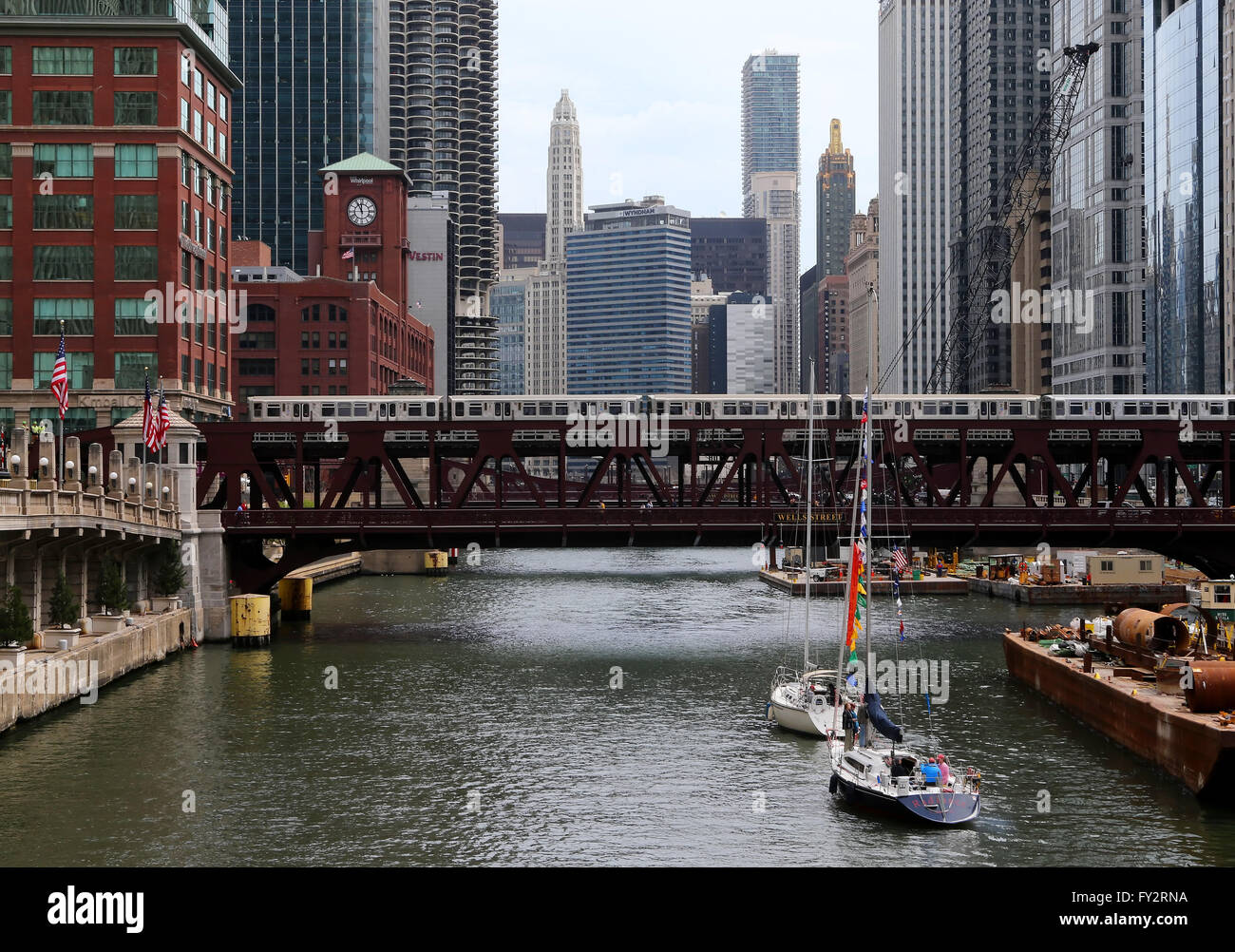 Segelboote warten ein CTA erhöhten Zug nach Wells Street Bridge zu löschen, wie sie ihren Weg auf dem Chicago River in Chicago Stockfoto