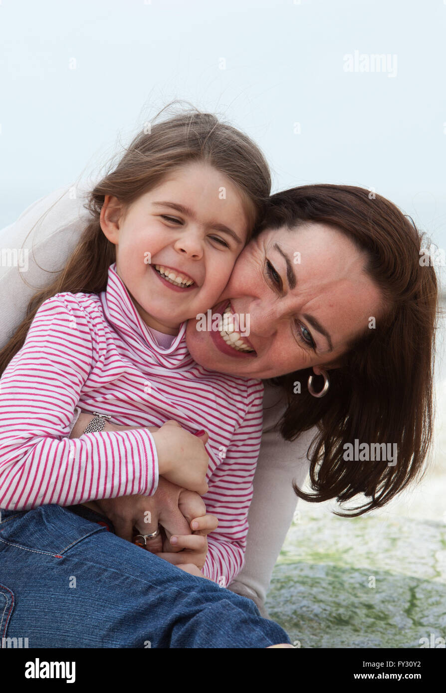 Mutter und Tochter kuscheln am Strand Stockfoto