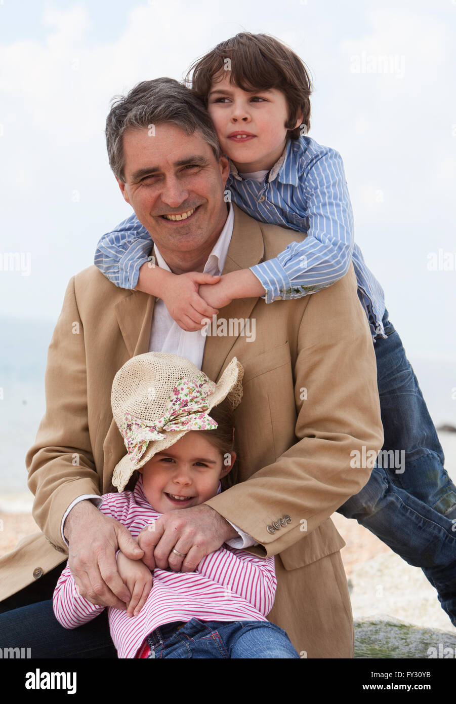 Papa und zwei Kinder am Strand Stockfoto