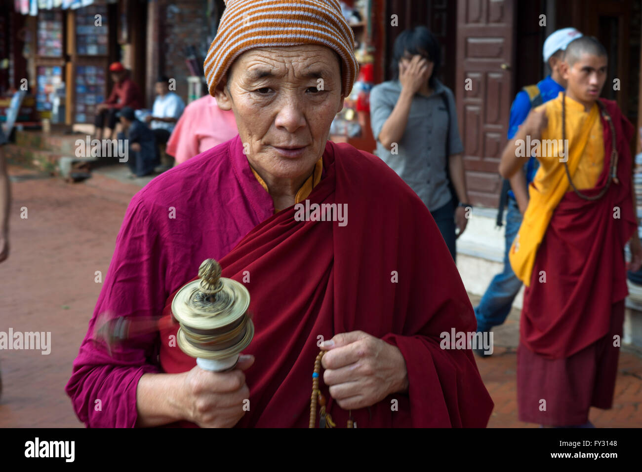 Mann mit einem Mani-Mühle in Boudhanath Stupa, Kathmandu, Nepal. Mani-Mühle, Bodhnath Stupa, Kathmandu, Nepal, Asien Stockfoto