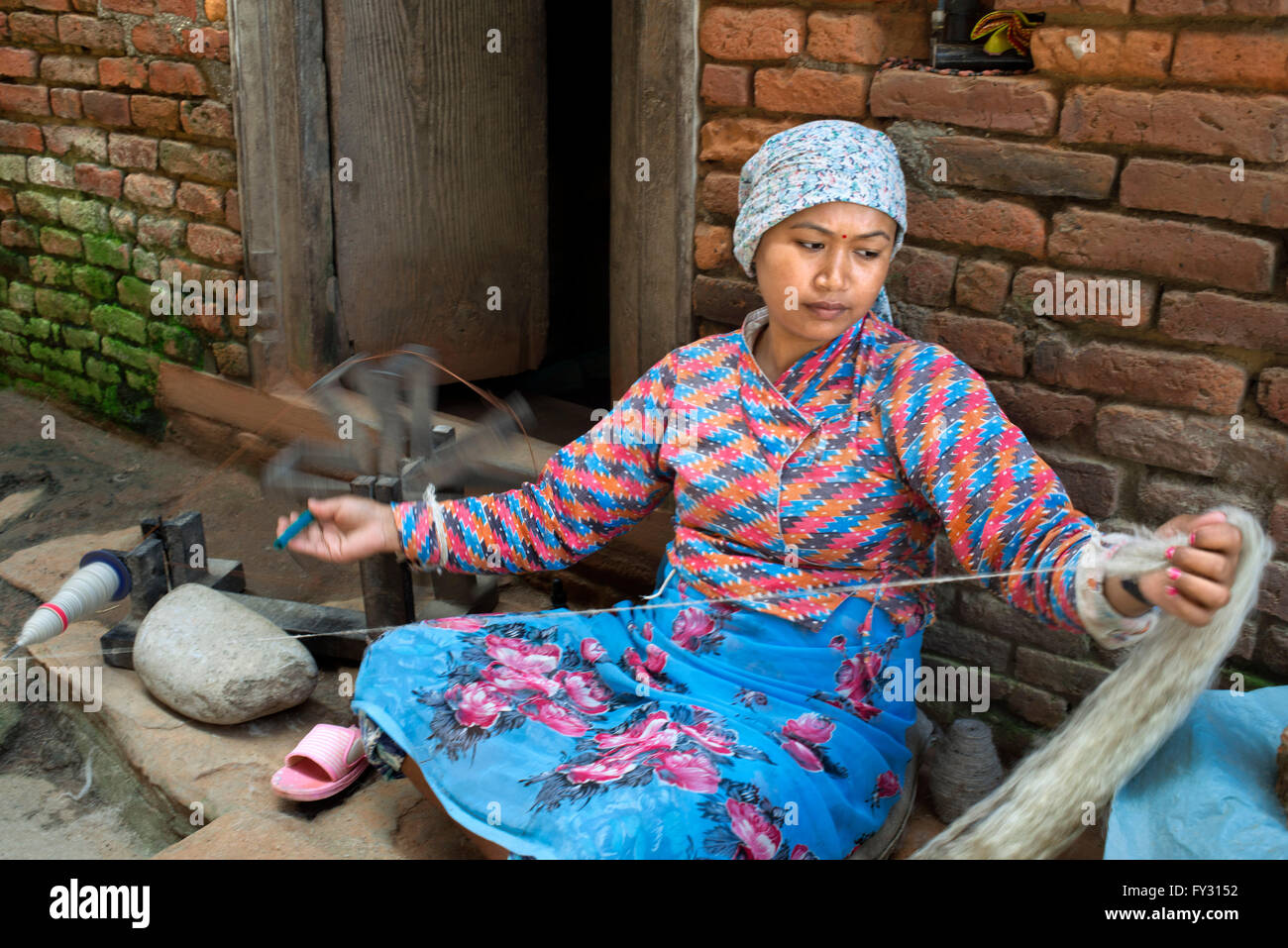 Eine Frau dreht sich Wolle in dem kleinen Dorf Bungamati, Nepal Stockfoto