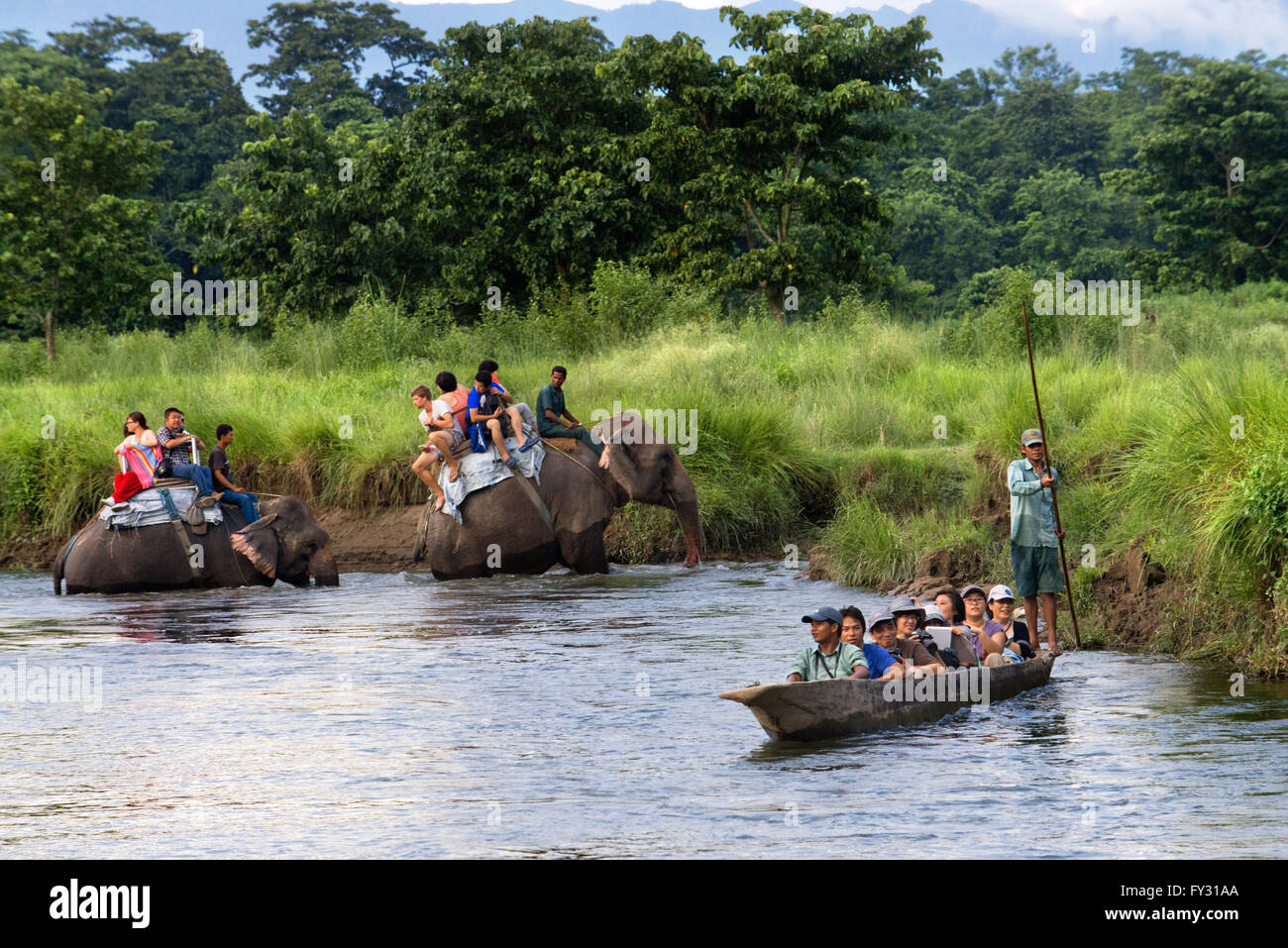 Bootsfahrt und Nashorn und Touristen auf Elefantsafari auf dem Rapti Fluss, Chitwan Nationalpark, Nepal, Asien Stockfoto