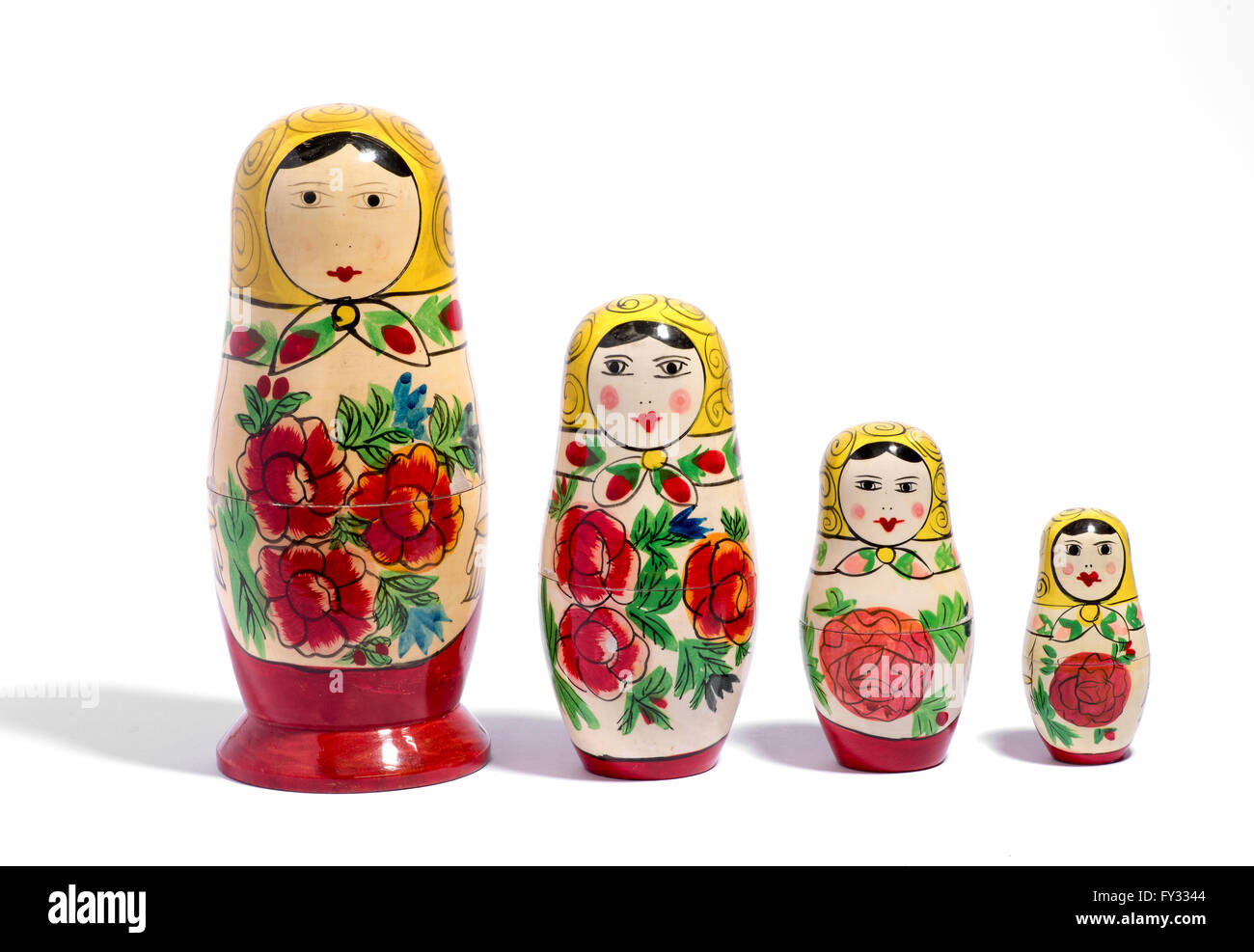Reihe von vier russischen Matroschka Puppen aufgereiht nebeneinander auf weißem Hintergrund mit Schatten Stockfoto