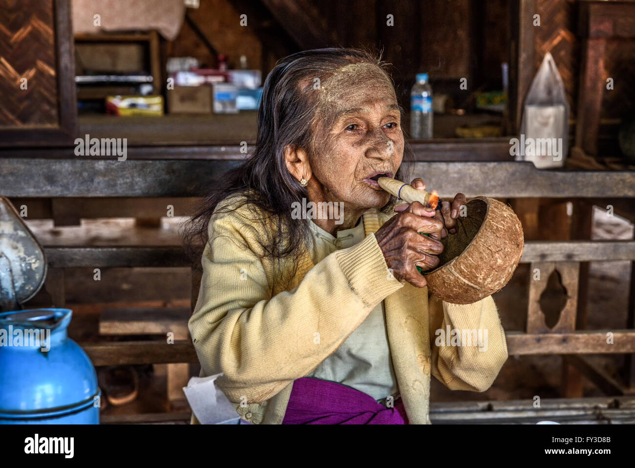 Alte Frau leuchtet eine Cheroot Zigarre Stockfoto