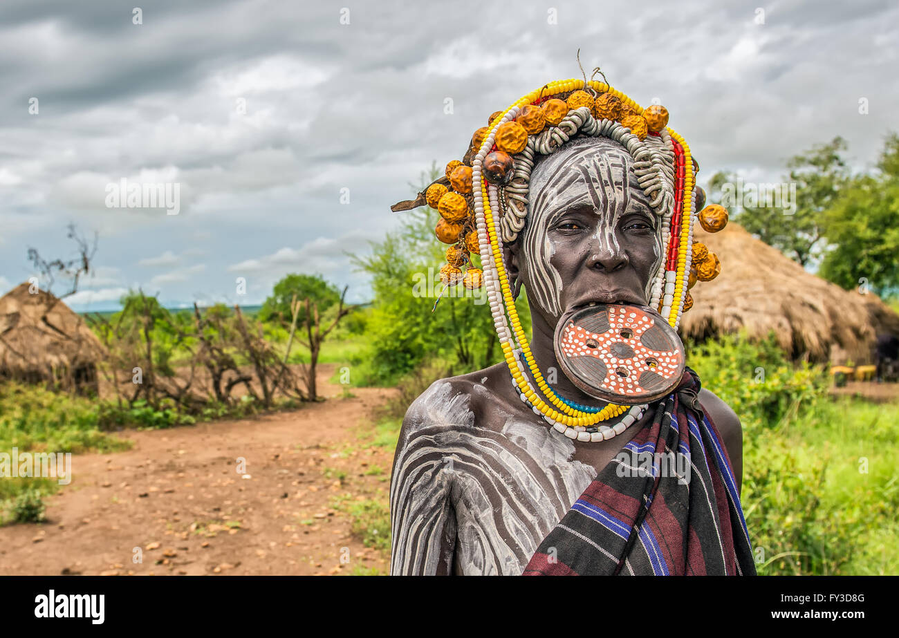 Frau aus dem afrikanischen Stamm Mursi mit einer großen Mundlochplatte in ihrem Dorf. Stockfoto