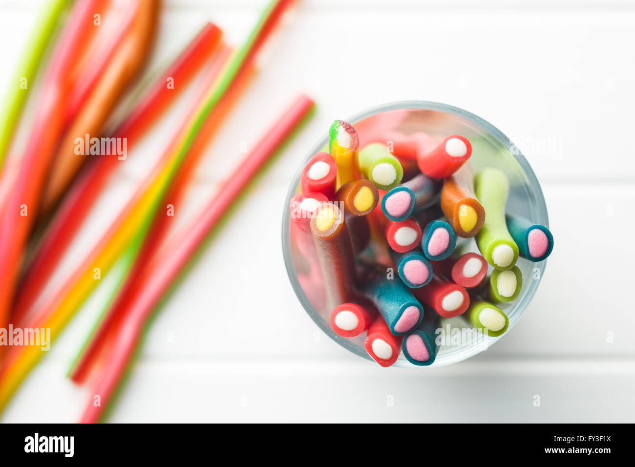 Süße Gummibärchen-Sticks mit unterschiedlichen Geschmack. Draufsicht der leckeren Süßigkeiten in Glasschale. Stockfoto
