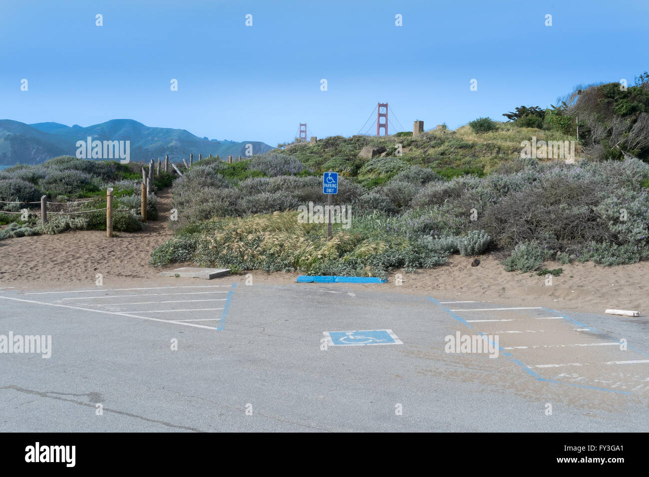 Eine unzugängliche Golden Gate Bridge und Marin Headlands sind in der Ferne hinter einem Hügel mit einer behinderten Parkplatz steht im Vordergrund mit einem blauen Stockfoto