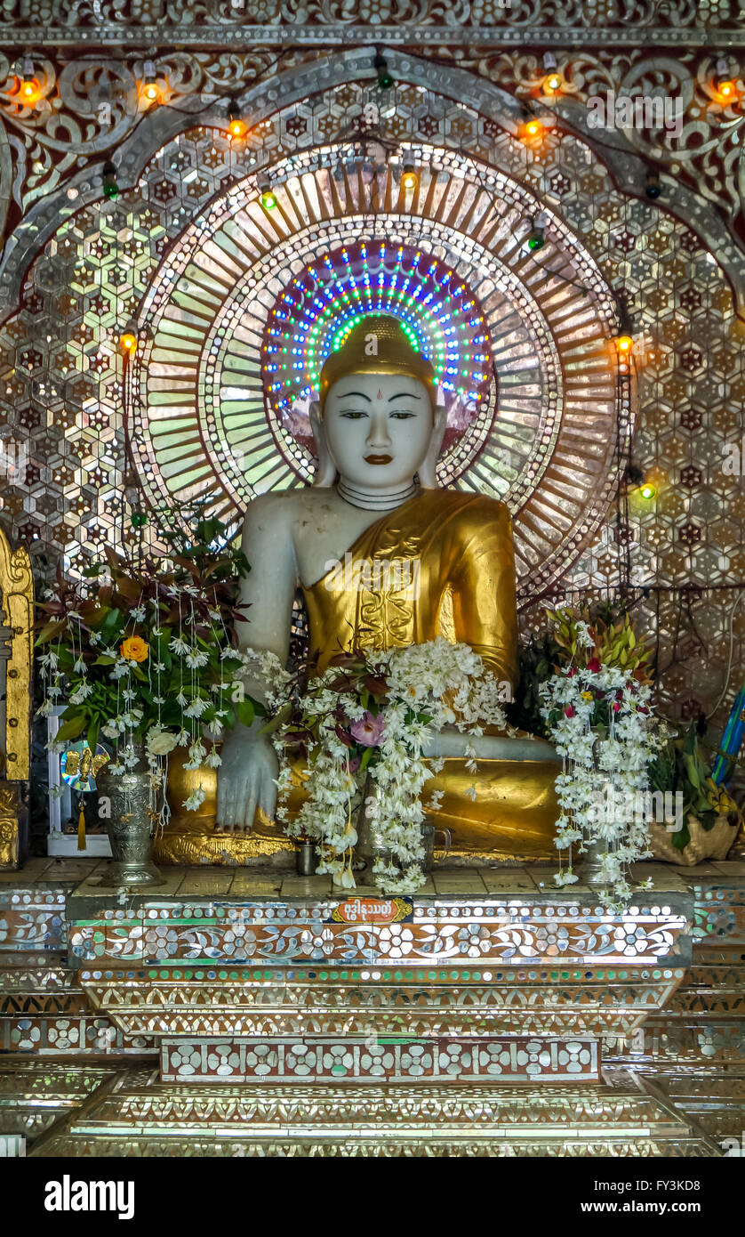 Goldenen Buddha in einem traumhaften Disneyland. Dies ist ein Buddha aus der Theravada-Tradition befindet sich in einer bestimmten Anordnung von Blumen Stockfoto