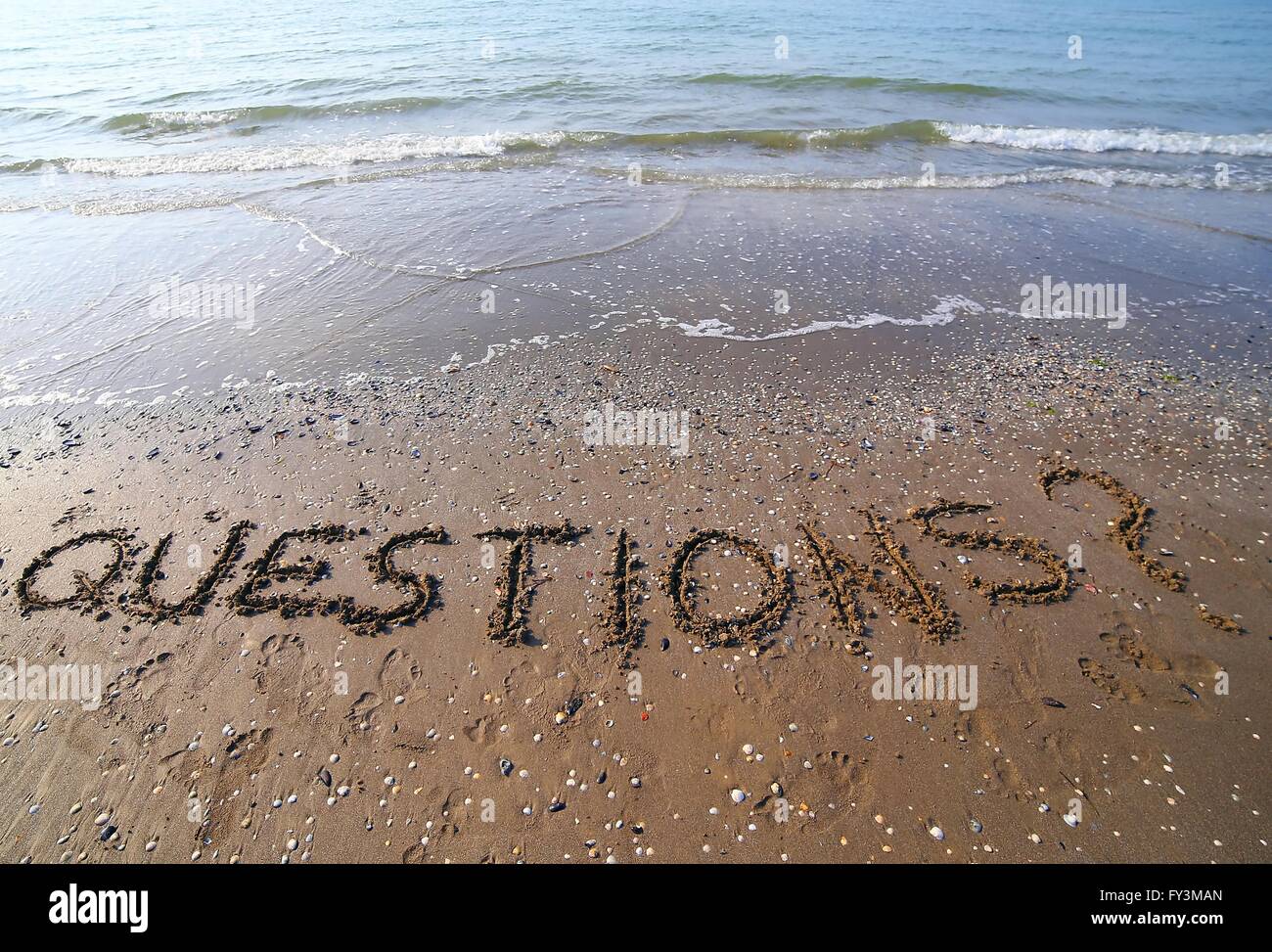 Wort-Fragen geschrieben in großen Lettern auf dem Sand des Meeres im Sommer Stockfoto