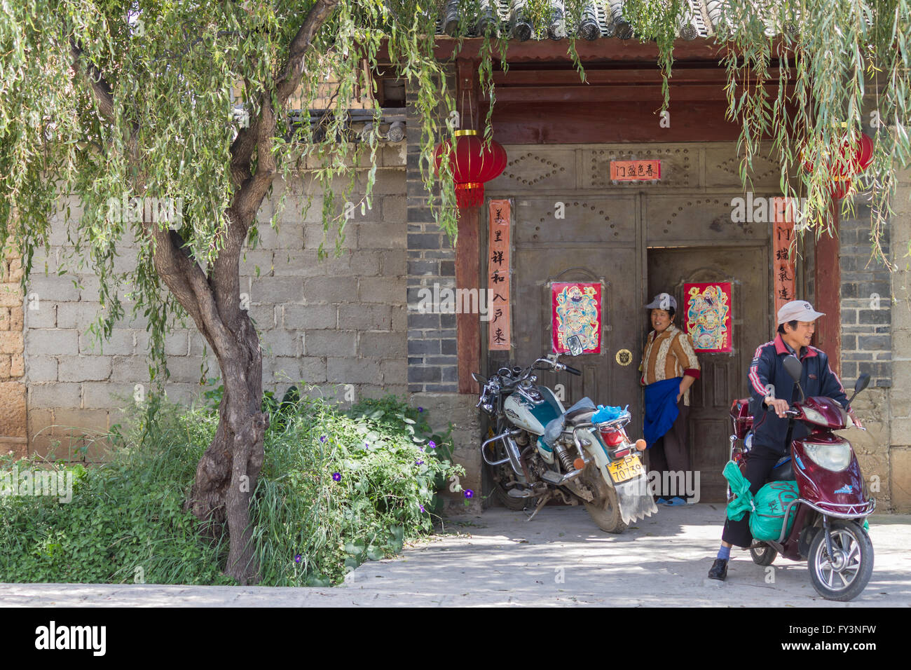 Lijiang, China: 2 Personen vor traditioneller chinesischer Architektur Stockfoto