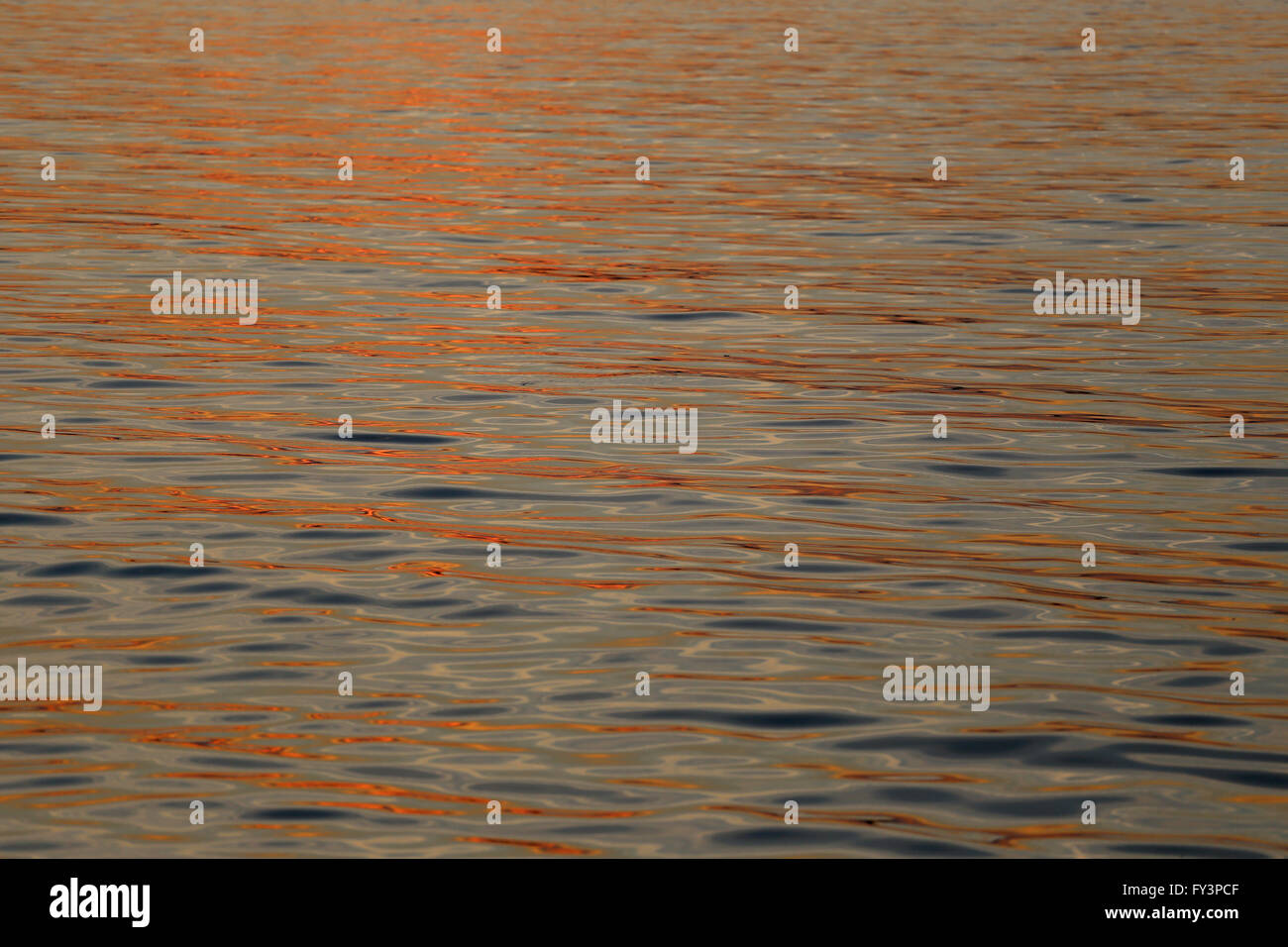 Reflektierte Licht des Sonnenuntergangs am Abend auf Welle im Meer. Stockfoto